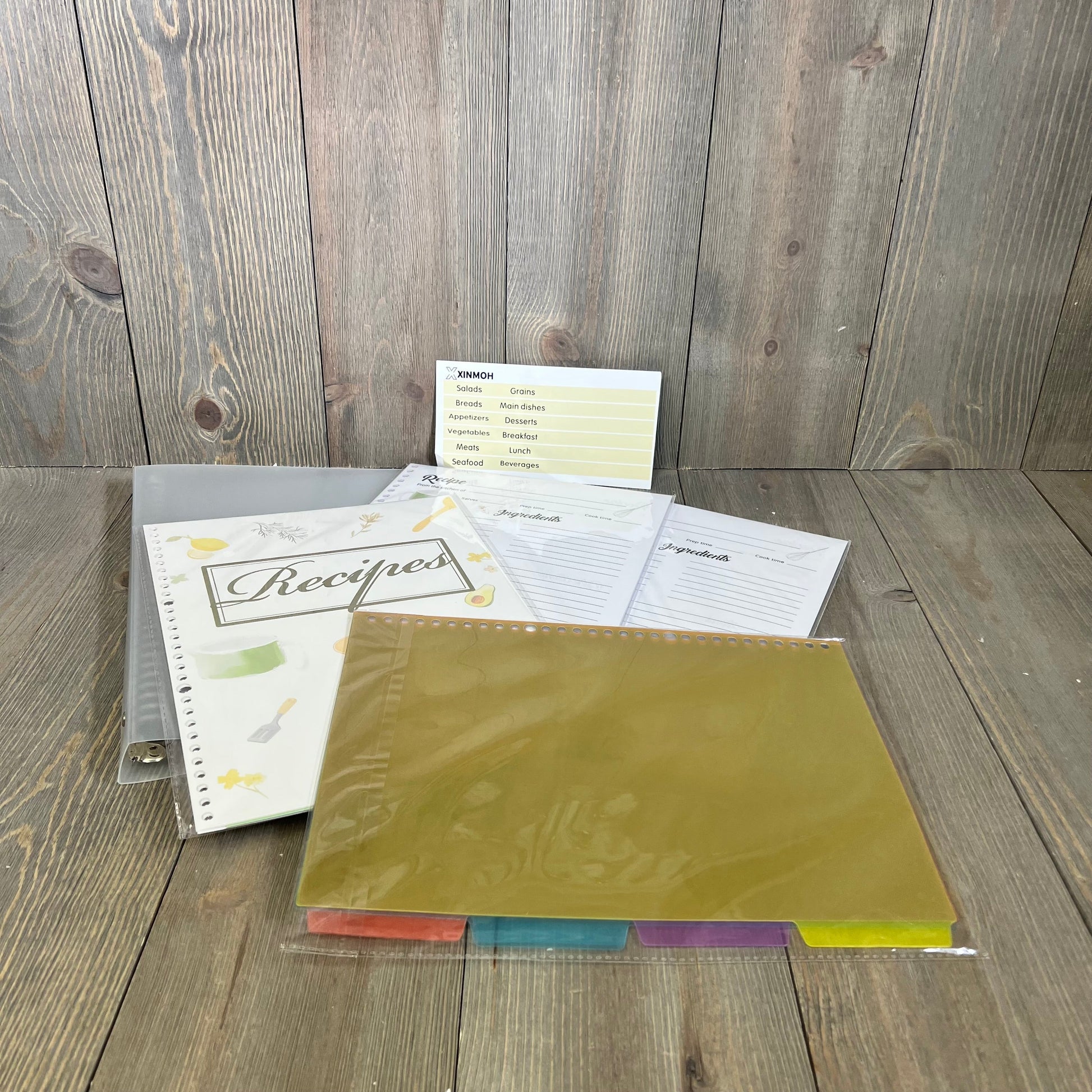 Recipe book set with dividers and tabs on wooden background, ideal for organizing and writing personal recipes.