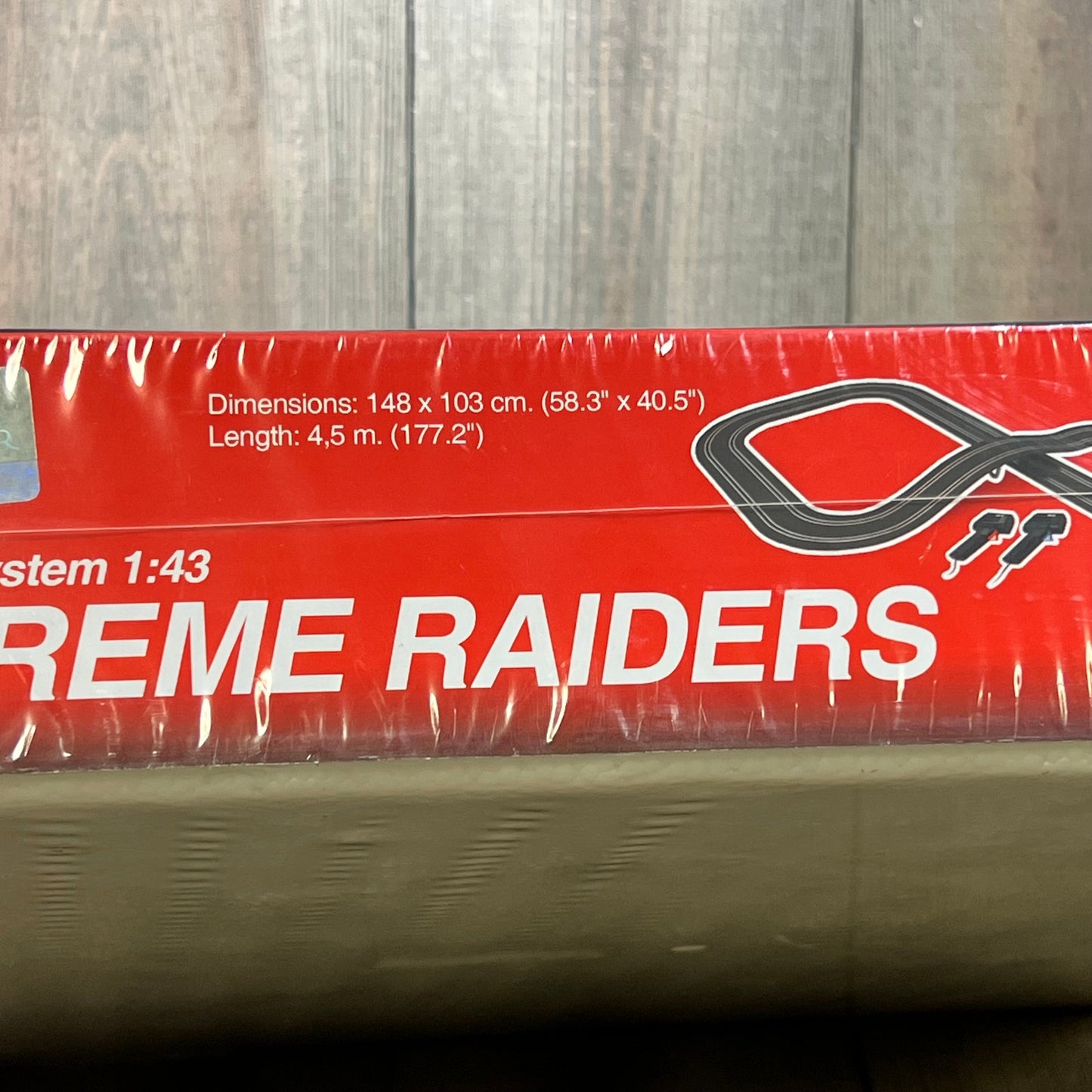 SCX Extreme Raiders 1:43 Scale Slot Car Set packaging displaying track dimensions and design details.