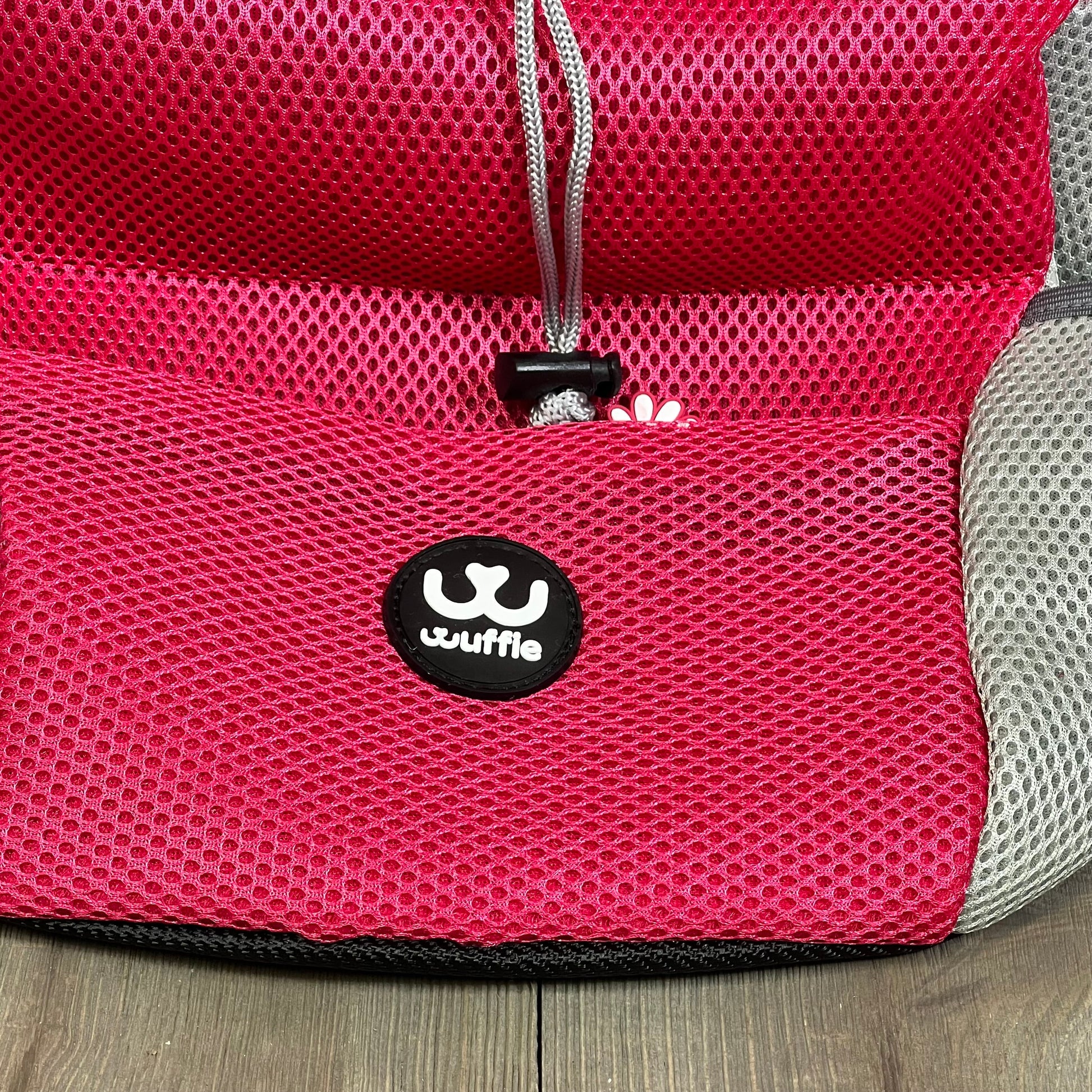 Pink wuffie pet carrier backpack with breathable mesh, adjustable straps, and secure safety belt for dogs.
