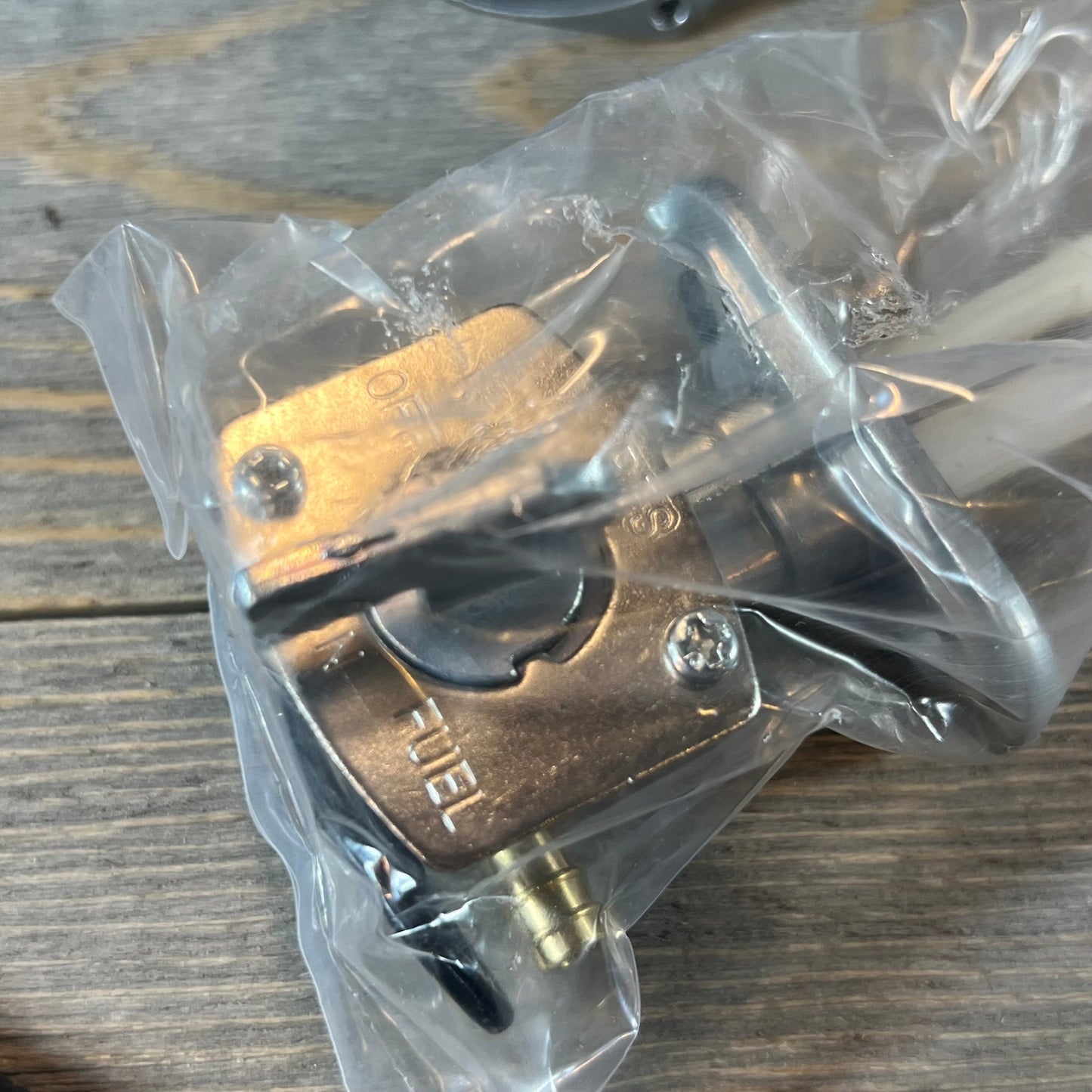 Replacement carburetor petcock for Suzuki LTZ400 Quad 2003-2007, shown in packaging on a wooden surface.