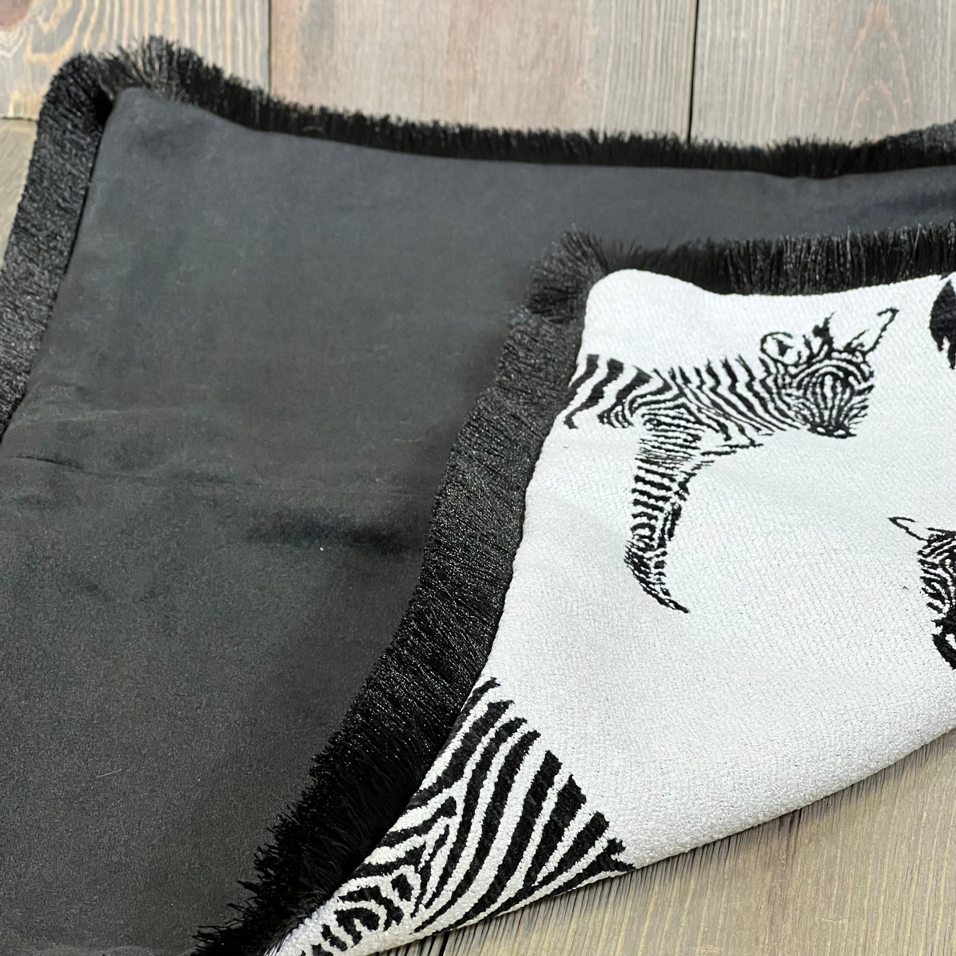 Luxurious throw pillow cover with jungle zebra embroidery, featuring a modern black-fringed edge for stylish home decor.