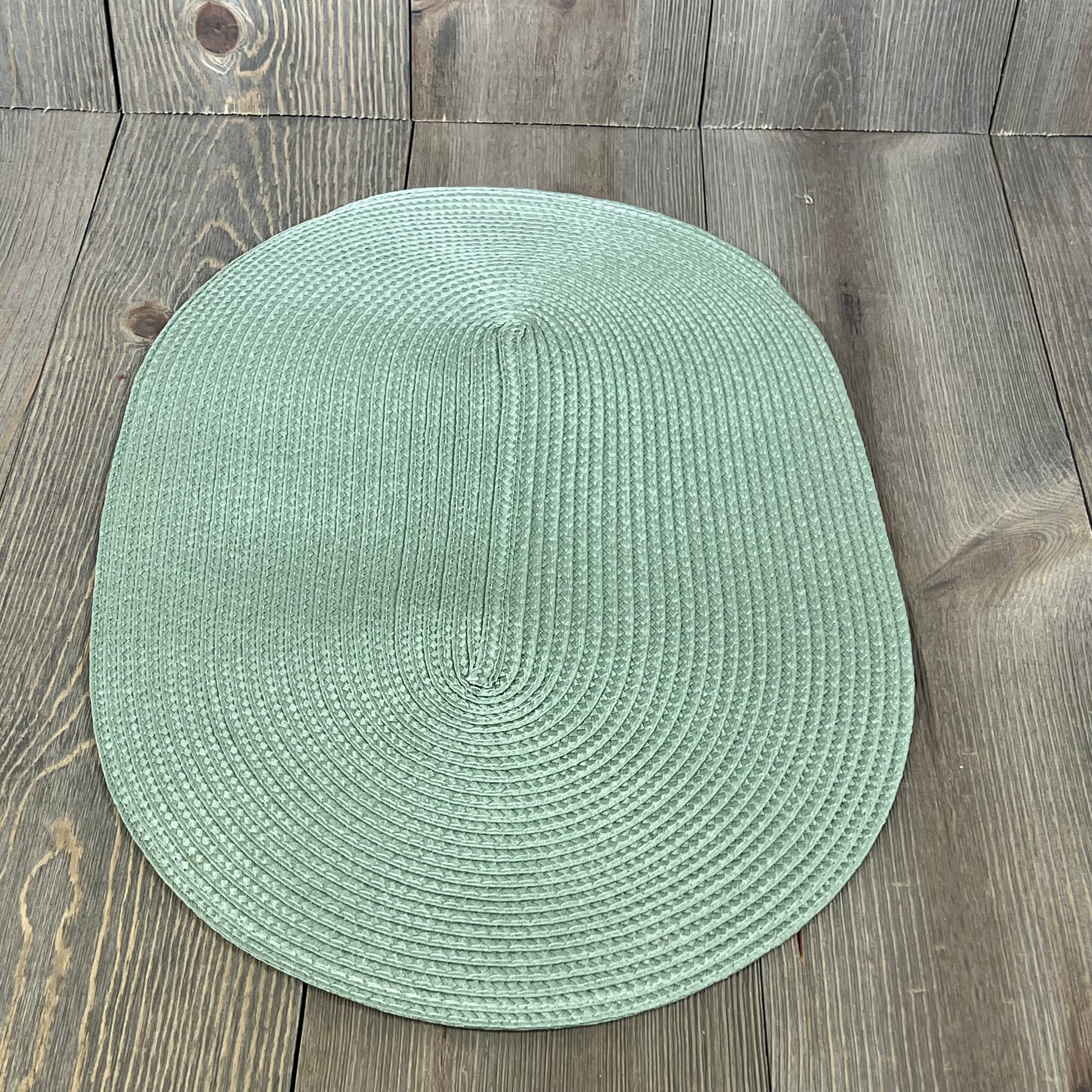 Sage green woven vinyl placemat, non-slip and washable, perfect for dining tables, 18x12 inches, heat-resistant and durable.