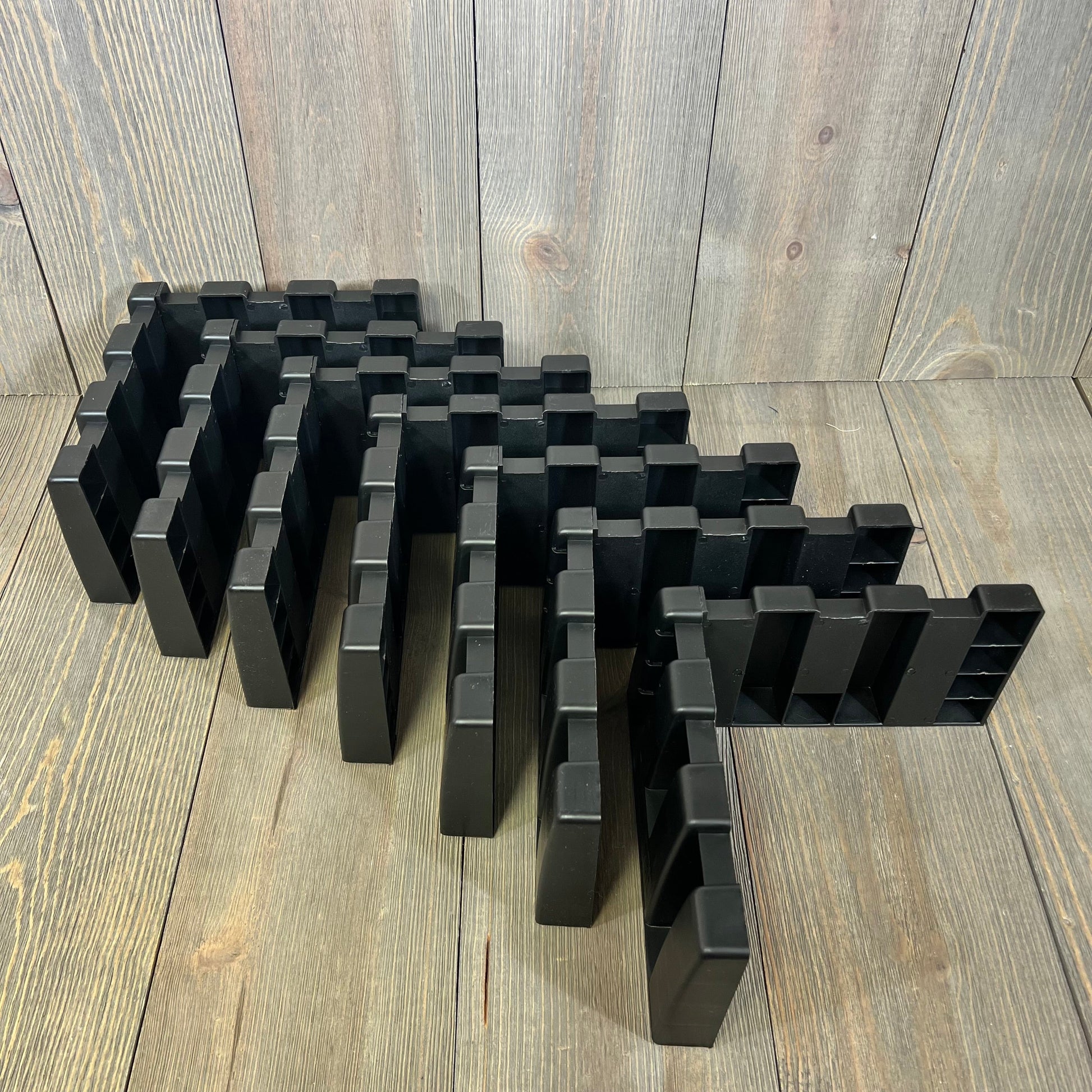 Black car trunk organizer blocks arranged on a wooden surface, ideal for SUVs and vans, enhancing cargo space management.