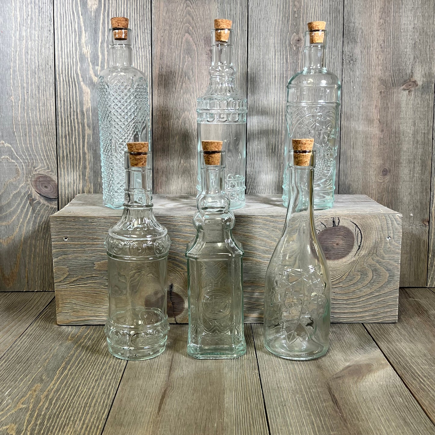 Assorted clear glass bottles with corks in various shapes, 6 pack, perfect for home decor or DIY projects.