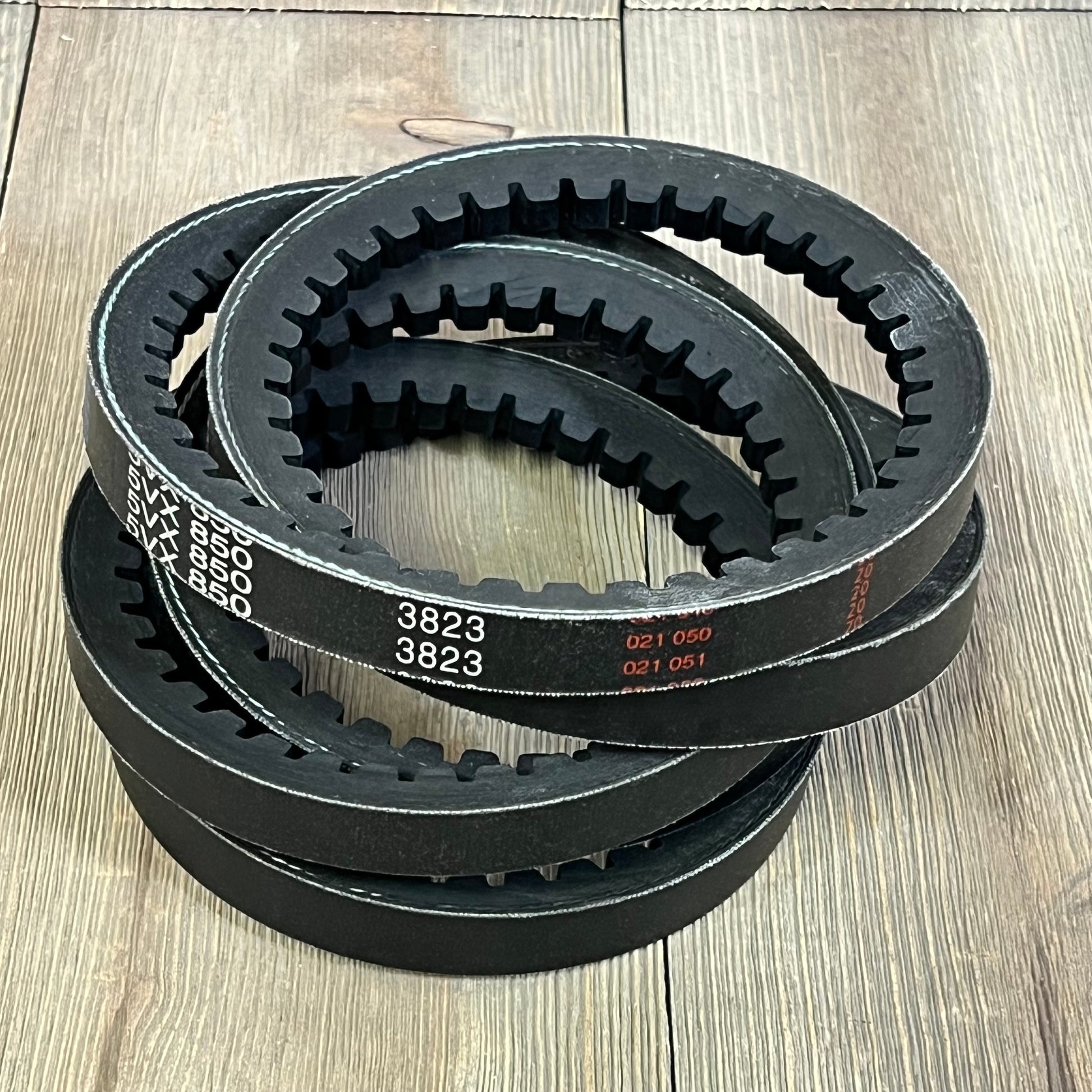 Stacked D&D PowerDrive 5VX850 V Belts, rubber construction, 5/8" x 85" OC, displayed on wooden surface.
