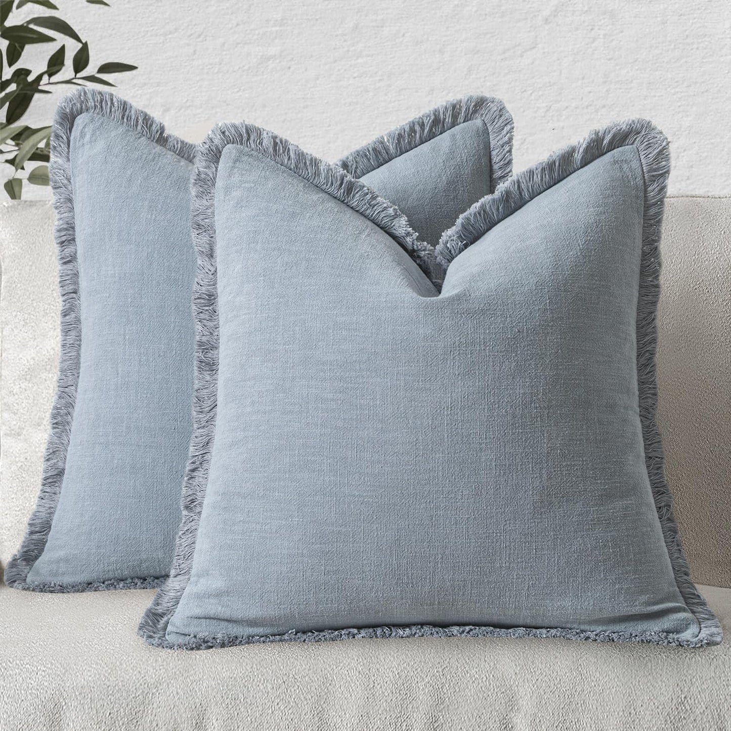 Light blue linen pillow covers with fringe, perfect for boho farmhouse decor on a sofa or bed, set of two, 20x20 inches.