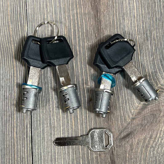 Durable metal lockable cylinder kit for Yakima car roof rack with keys on a wooden surface.