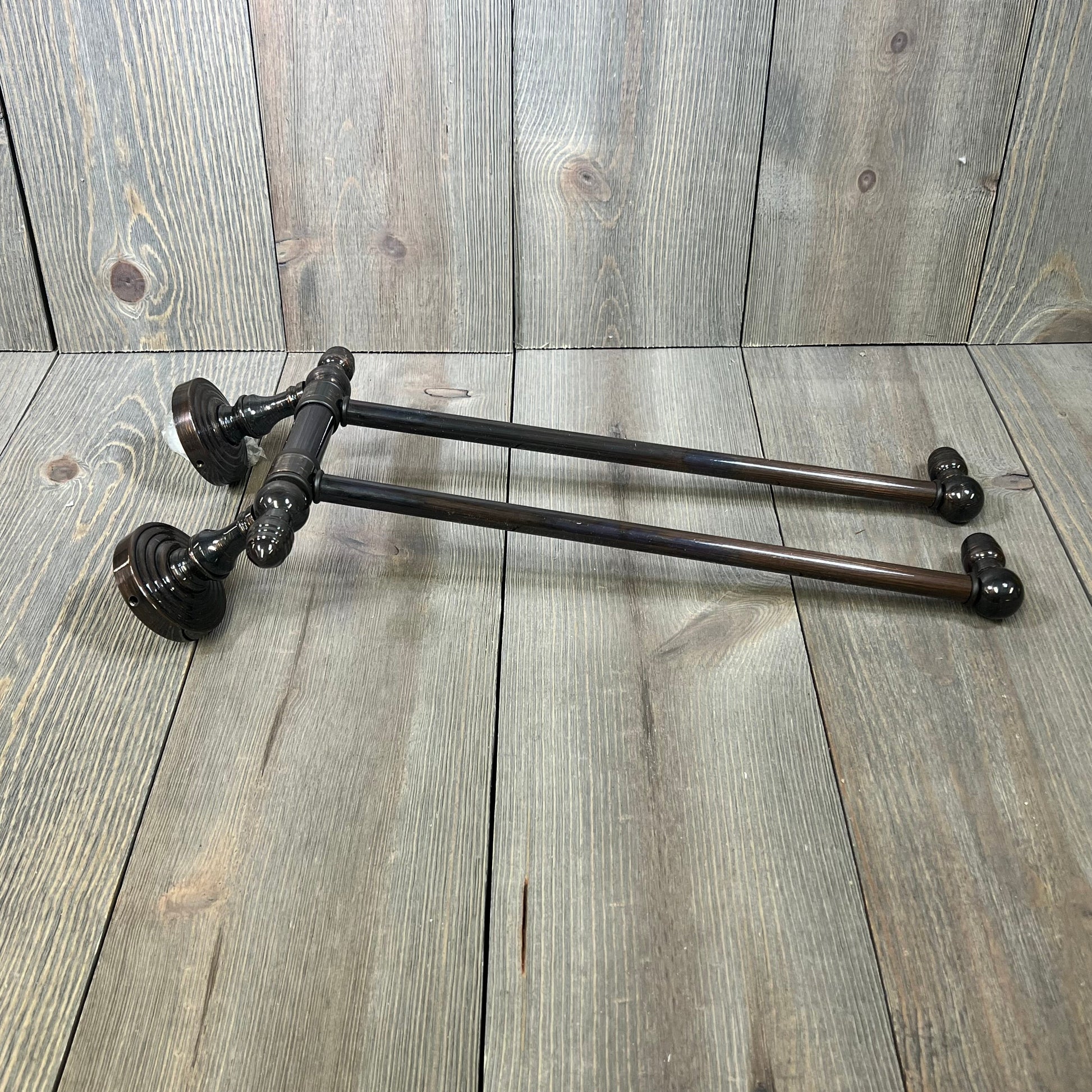 Antique copper swing arm towel rail from Allied Brass Waverly Place Collection, showcasing elegant dual arms on wooden background.