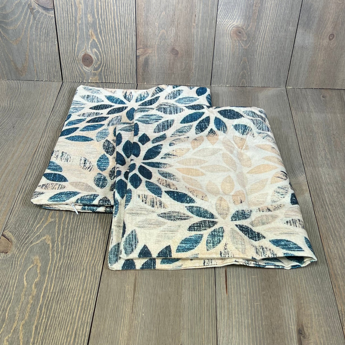 Navy blue and cream dahlia lumbar pillow covers with geometric floral design on rustic wood background.
