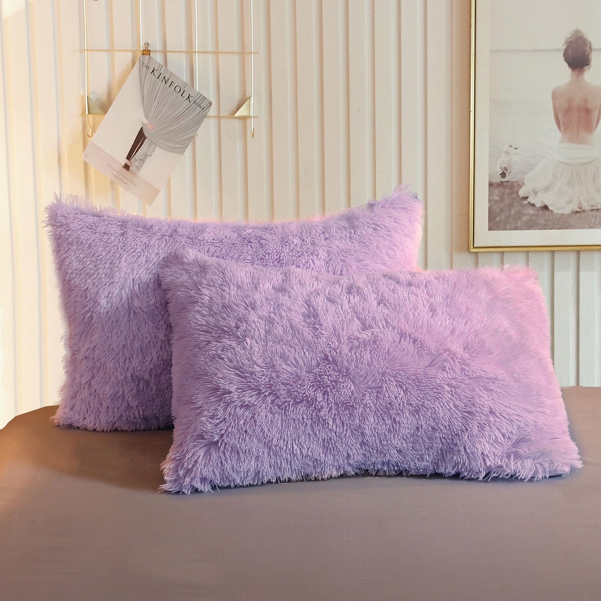 Fluffy lavender faux fur throw pillow cases on a stylish bed, adding a plush touch to bedroom decor.