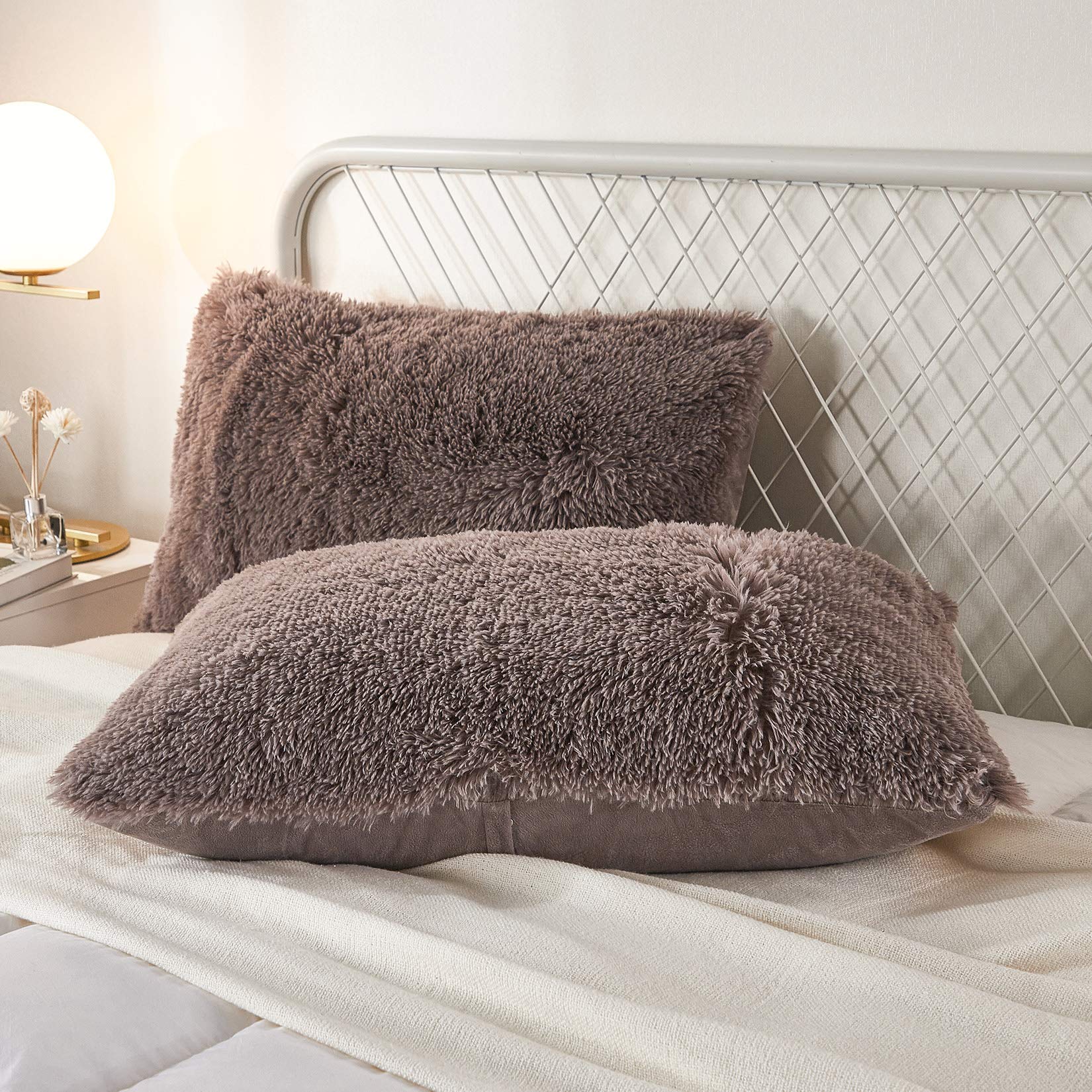 Luxurious purplish taupe faux fur pillow covers on bed, adding elegance and comfort to bedroom decor.