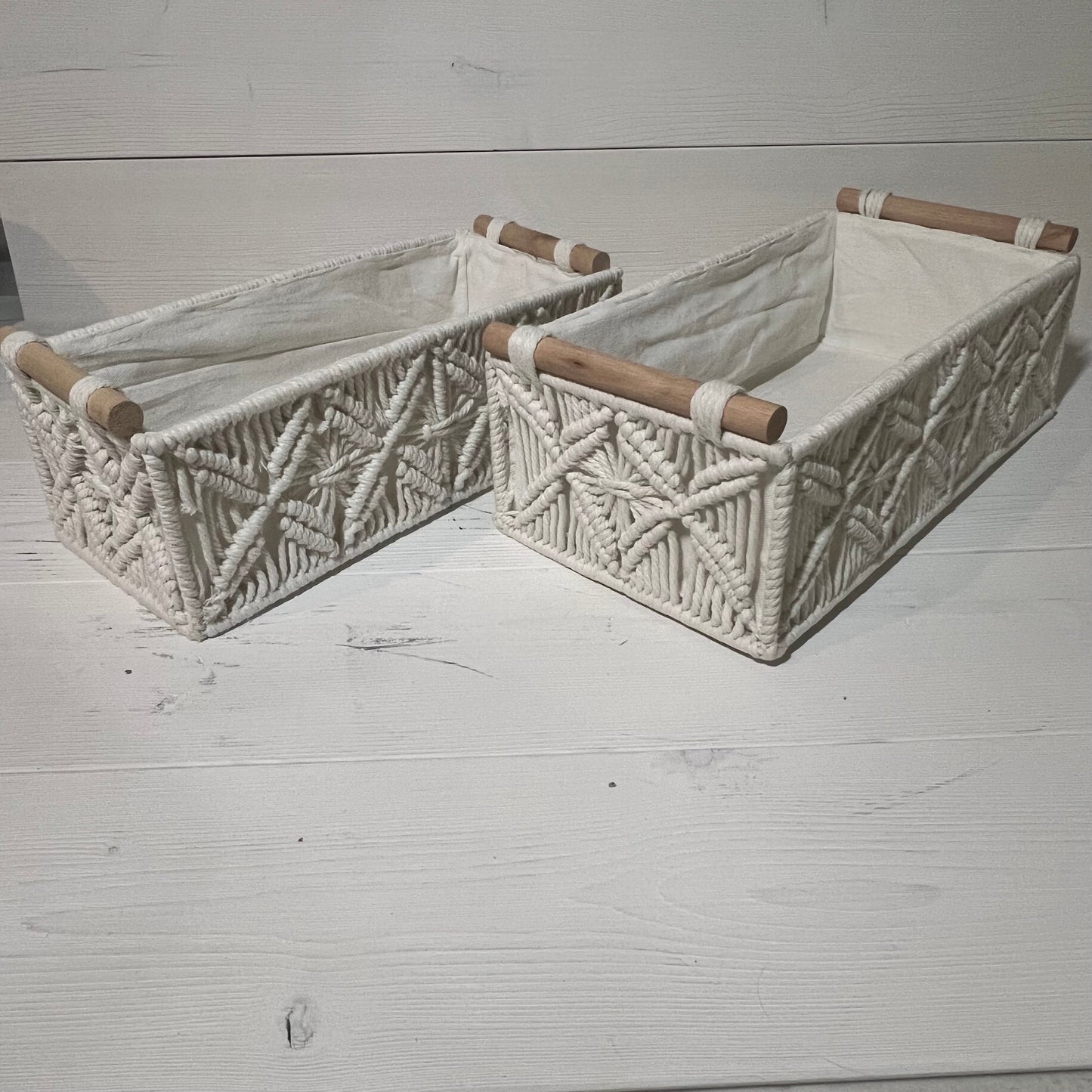 Handwoven macrame storage baskets in ivory white, featuring wooden handles, perfect for bathroom or bedroom organization.