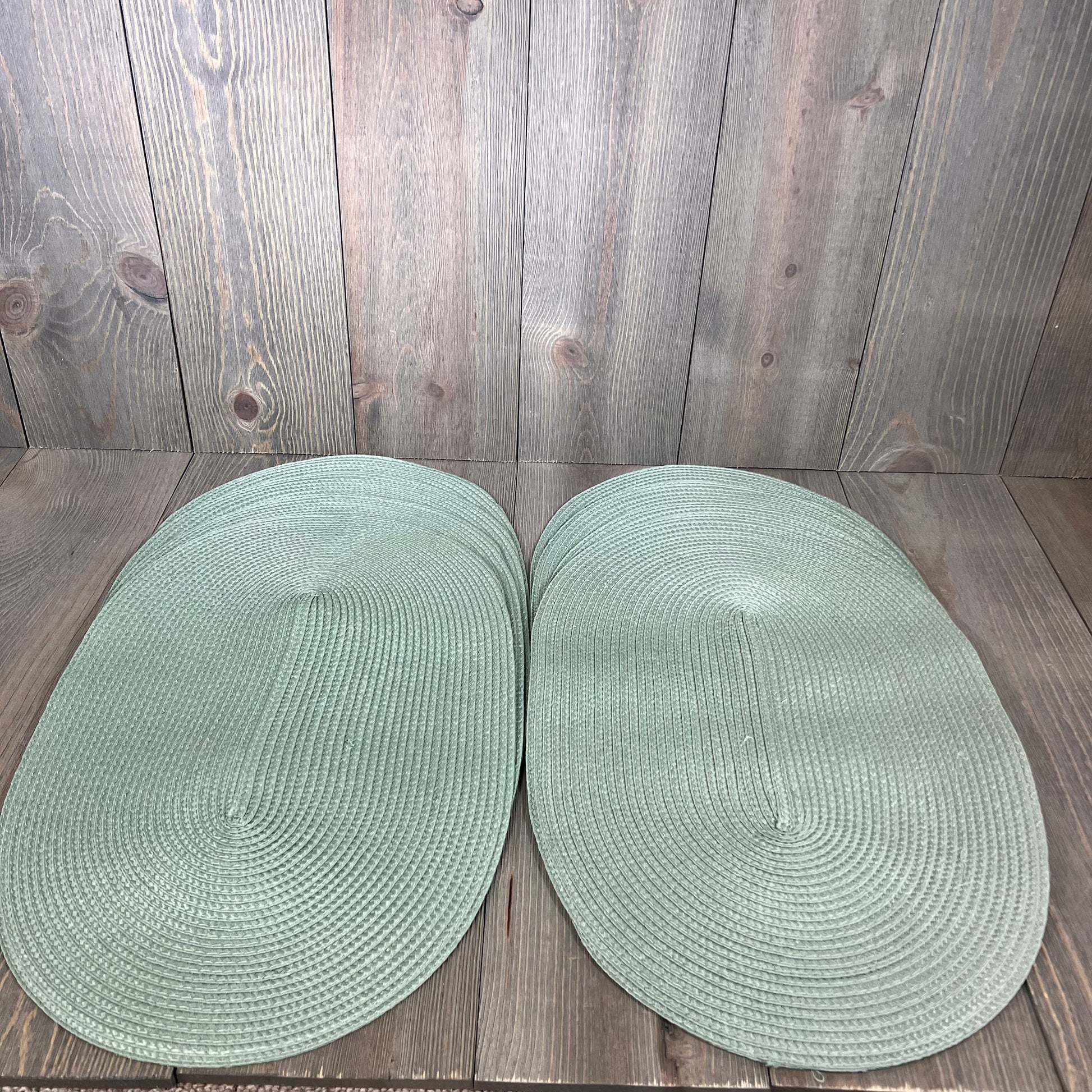 Sage green woven vinyl placemats set of 8 on wooden table, non-slip and heat-resistant, perfect for dining decor.