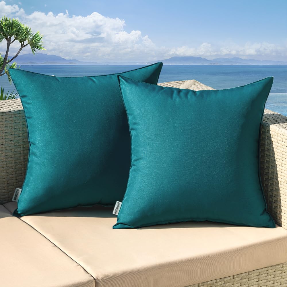 Teal blue outdoor pillow covers on a patio sofa, perfect for garden decor and waterproof for spring weather.