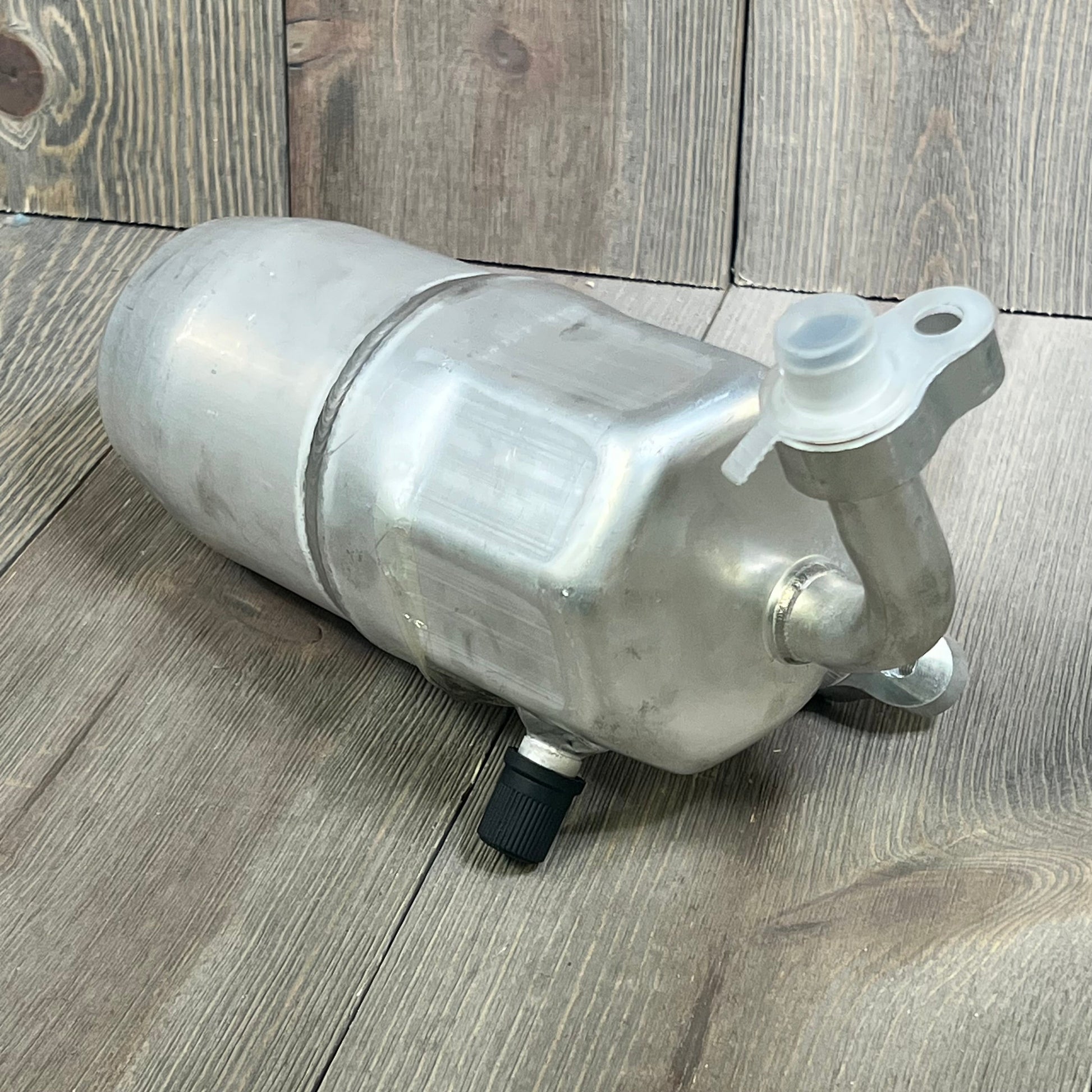 Universal Air Conditioner RD 1801C A/C Accumulator, aluminum body on wooden surface, ideal for car cooling systems.