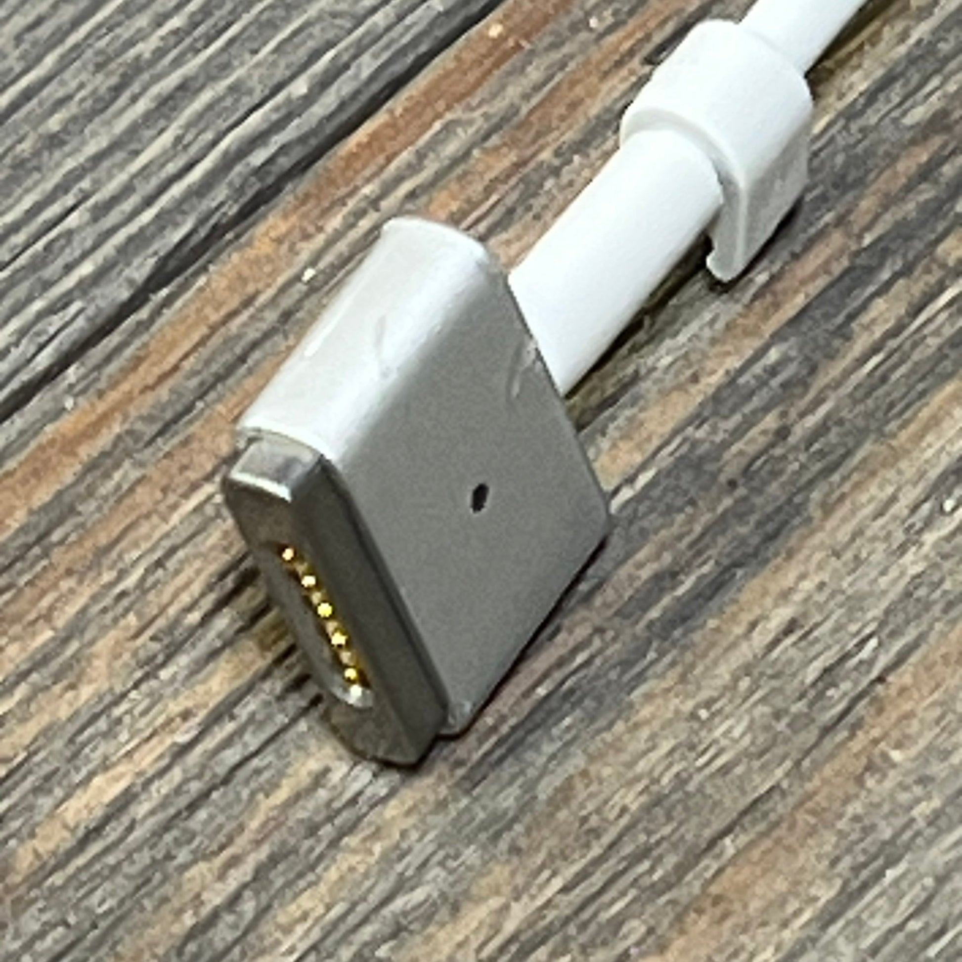 Magnetic Type-C cable connector for 140W MacBook Pro charger, showcasing durable design on wooden surface.