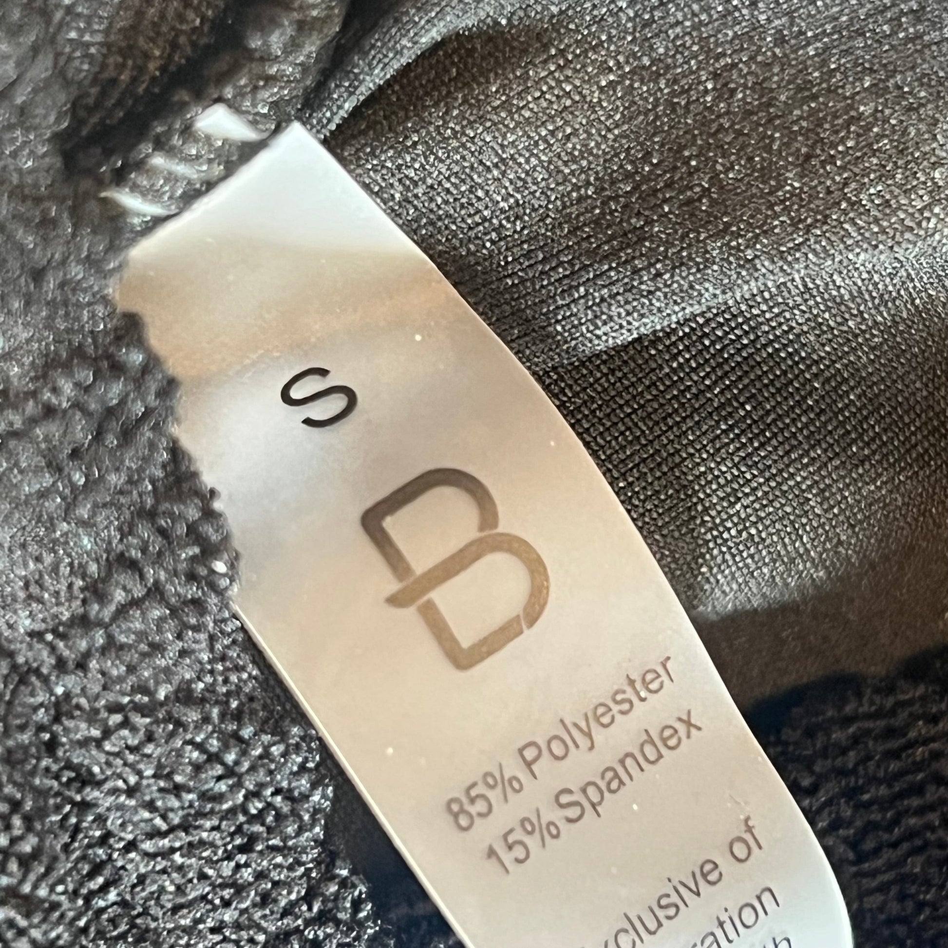 Small black Blooming Jelly bikini set label showing fabric composition of 85% polyester and 15% spandex.