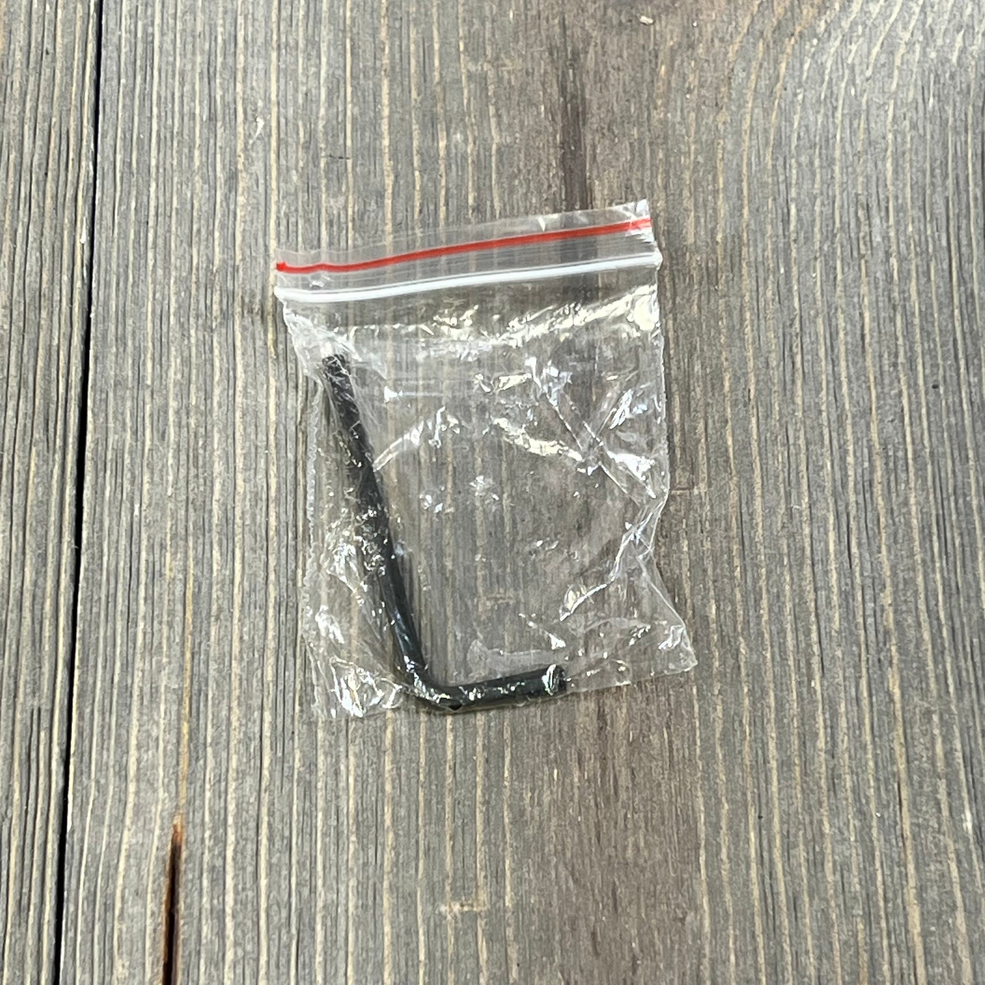 Hex key tool in a clear plastic bag for assembling the QYMOPAY 12.5 Inch Boat Steering Wheel, on a wooden surface.