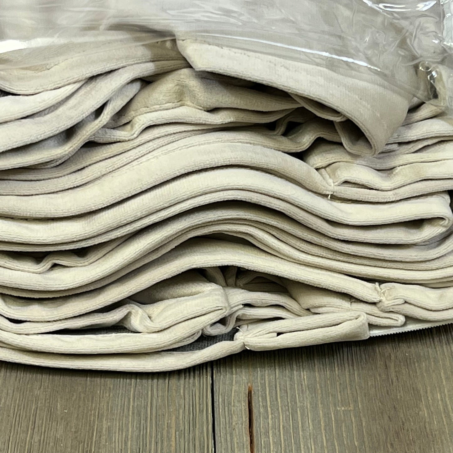 Folded beige velvet curtains, showcasing the luxurious texture of MIULEE blackout drapes, ideal for bedroom decor.
