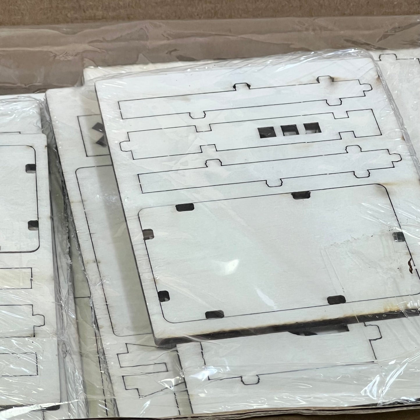 Unassembled wooden pieces for Hiboom DIY Christmas Village Set, ready for crafting festive holiday decorations.