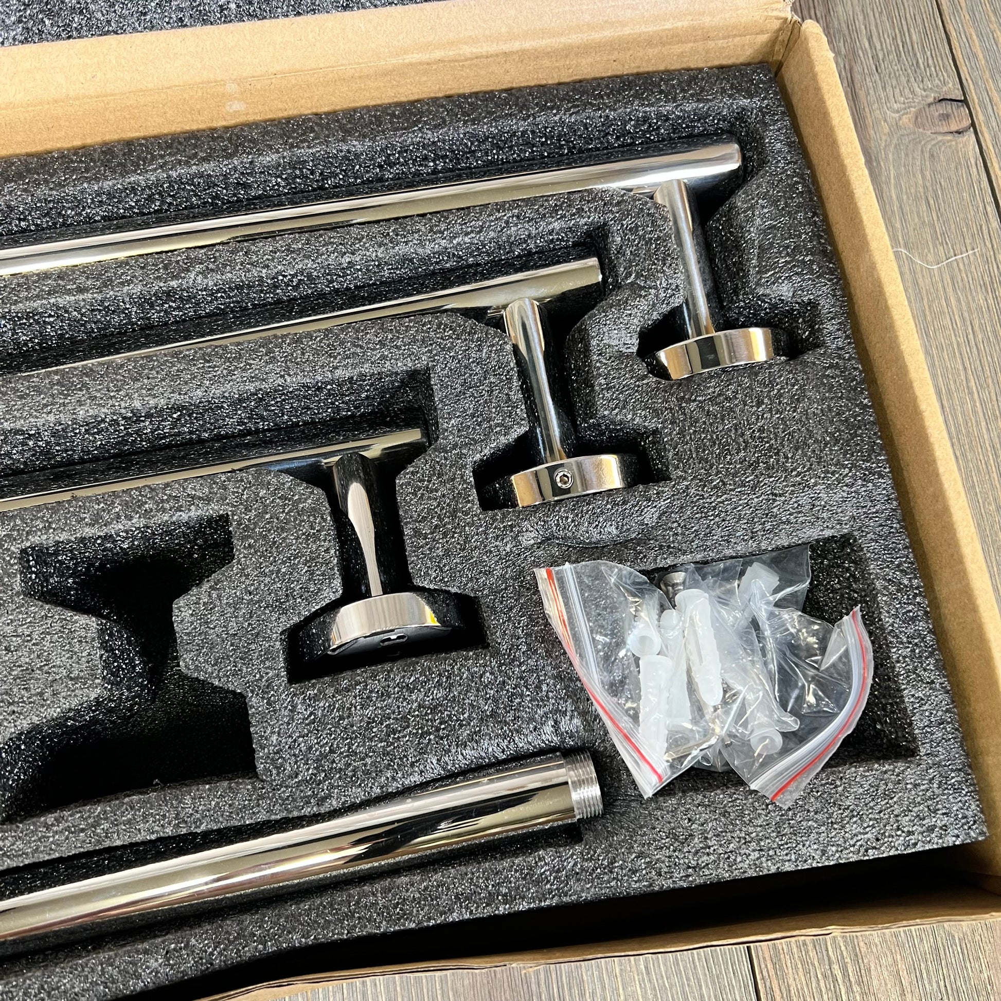 Stainless steel bathroom hardware set in packaging, featuring polished chrome towel bars and mounting accessories.