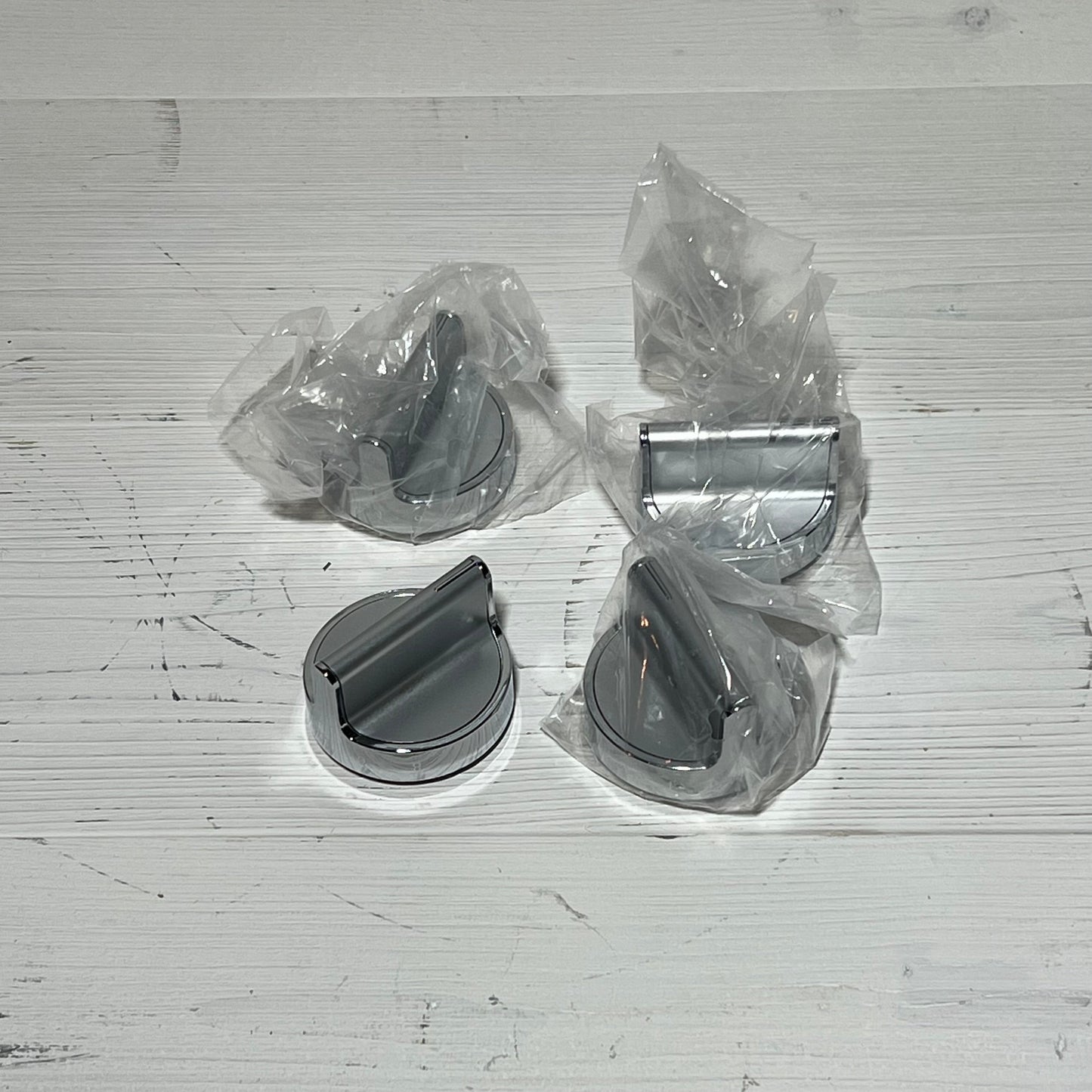 Stainless steel gas stove knobs replacement set for Whirlpool range, shown in packaging on a wooden surface.