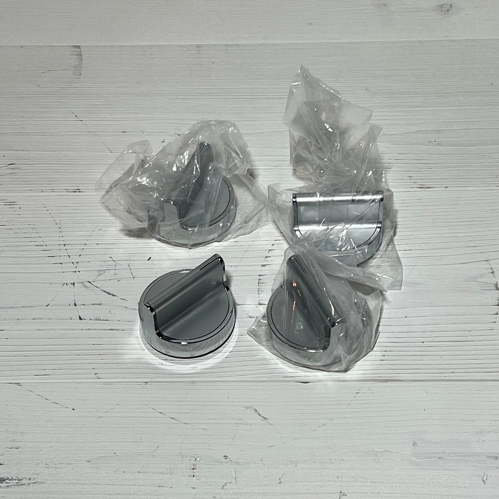 Stainless steel gas stove knobs replacement set for Whirlpool range, shown in packaging on a wooden surface.