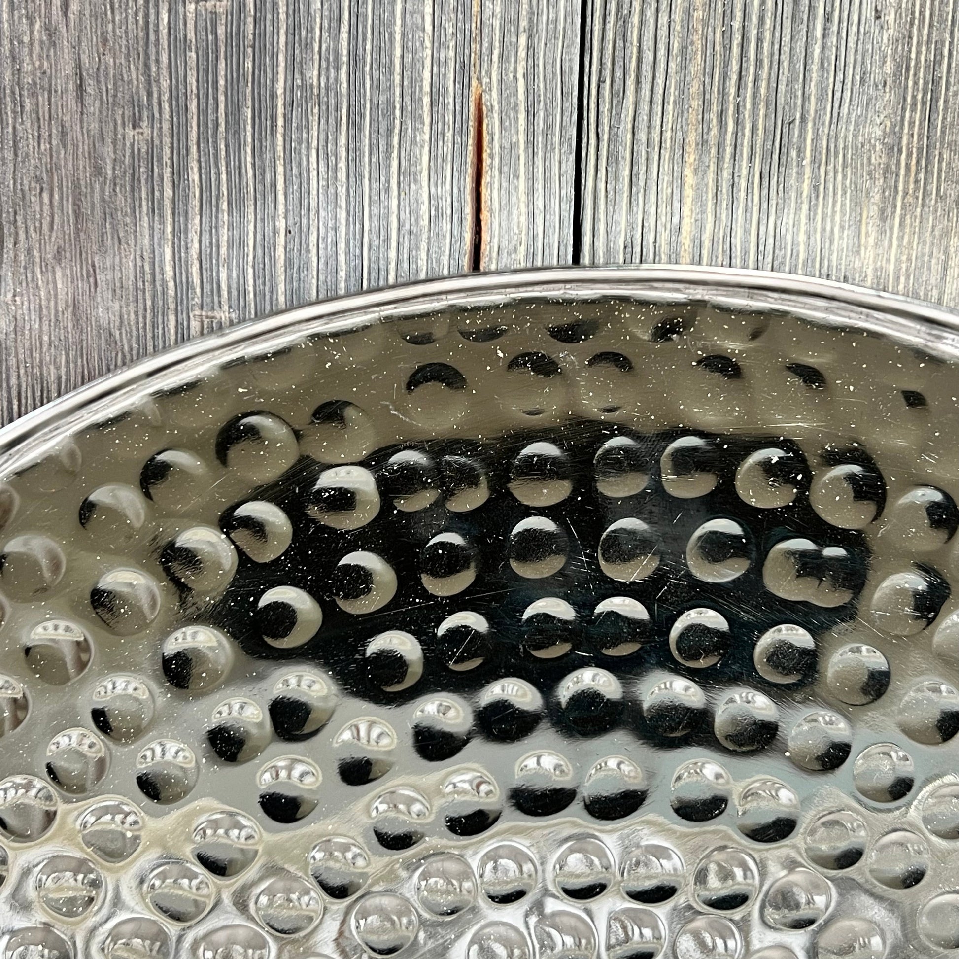 Hammered silver surface of 11-inch round decorative tray, perfect for candles, jewelry, or as a stylish coffee table accent.