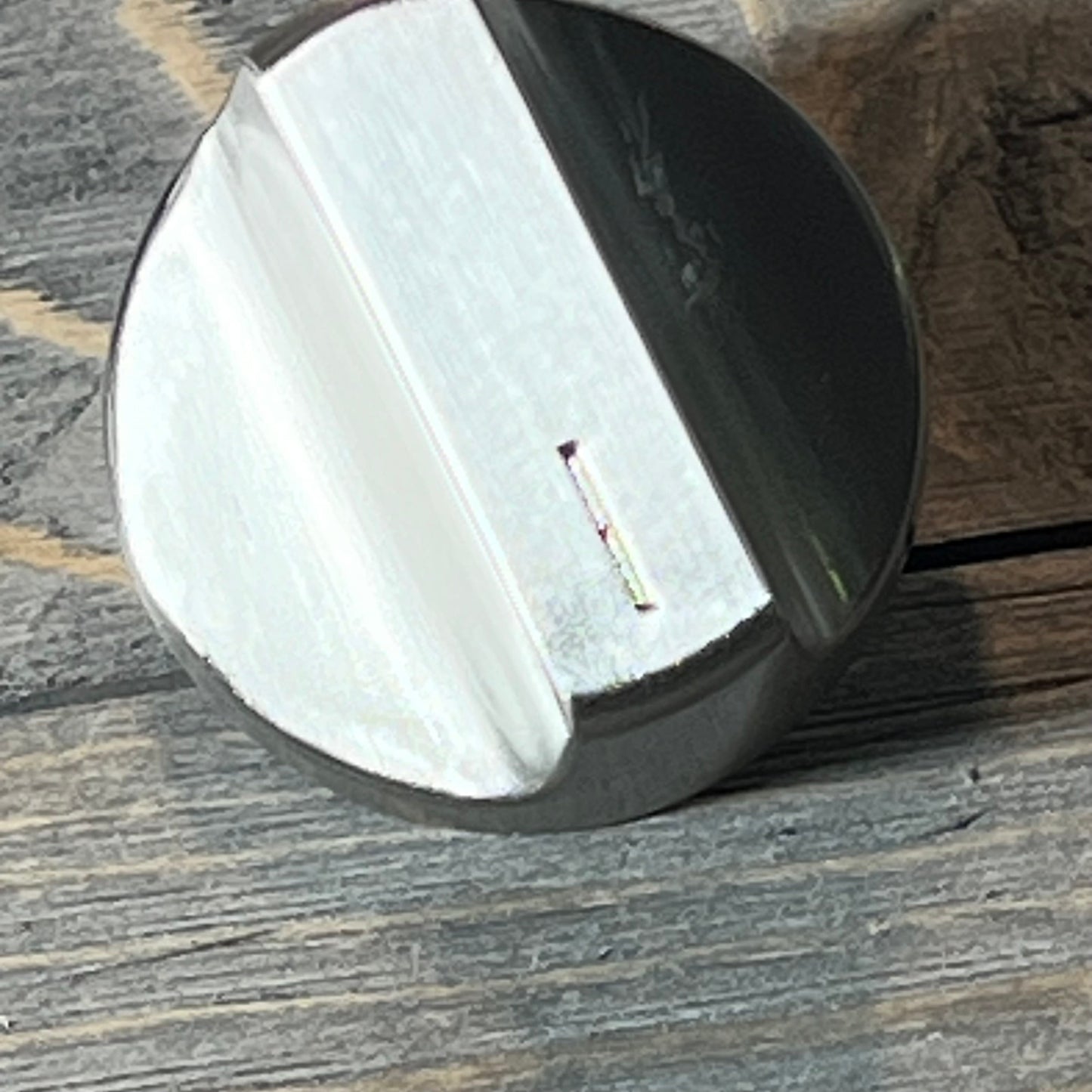 Stainless steel stove knob for Whirlpool gas range on wooden surface, showcasing sleek design and durable finish.