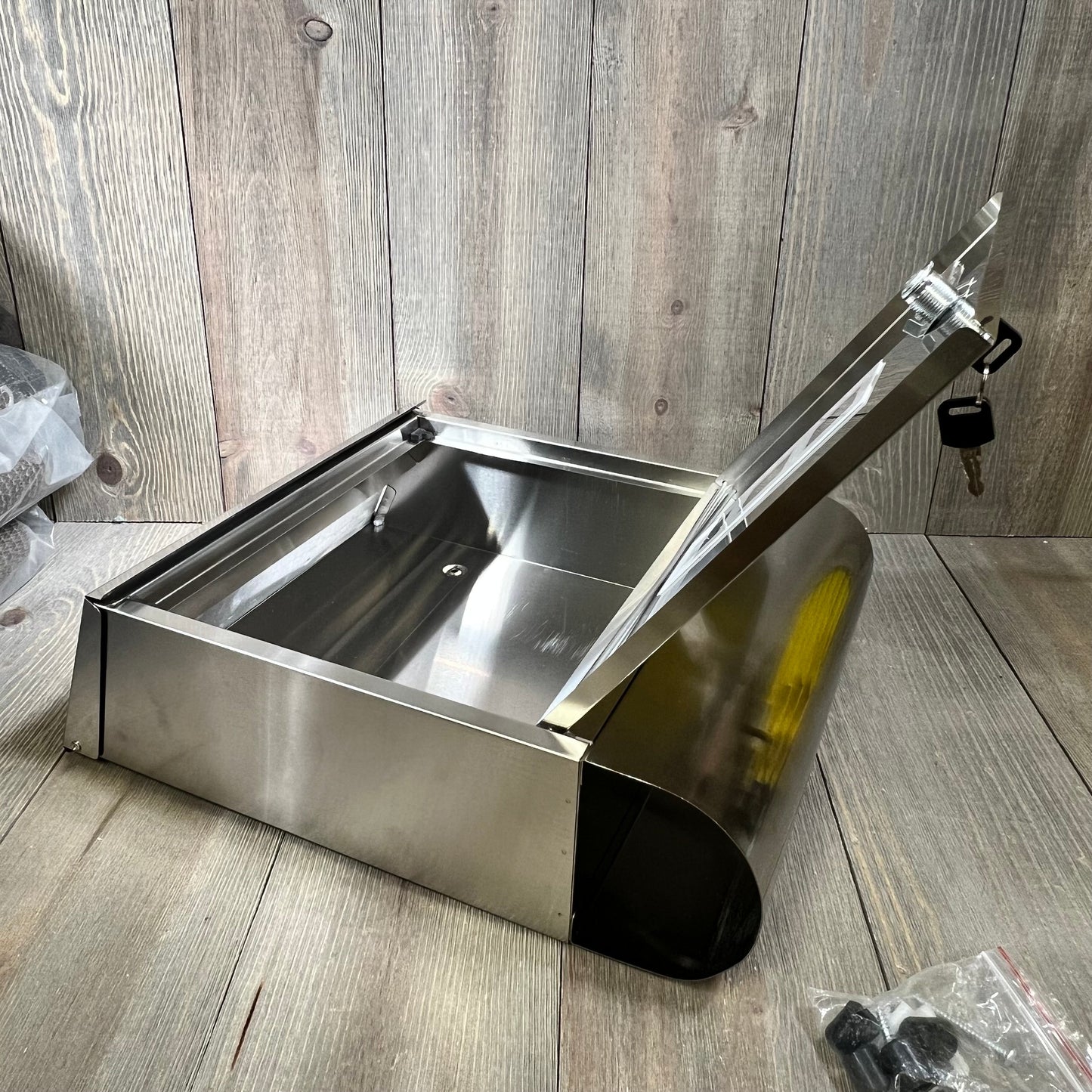 Wall-mounted stainless steel mailbox with open lid, showcasing spacious interior and secure key lock feature, ideal for large mail capacity.