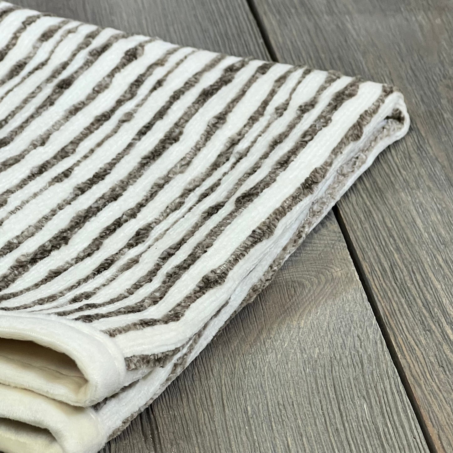 Dark brown chenille striped pillow cover folded on wooden surface, 18x18 inches, perfect for couch or bed decor.