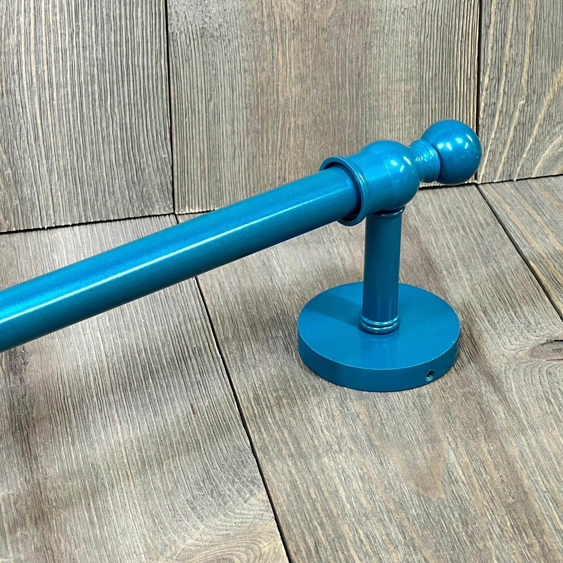 Teal towel bar from Allied Brass Skyline Collection, showcasing a sleek design on a wood-textured background.