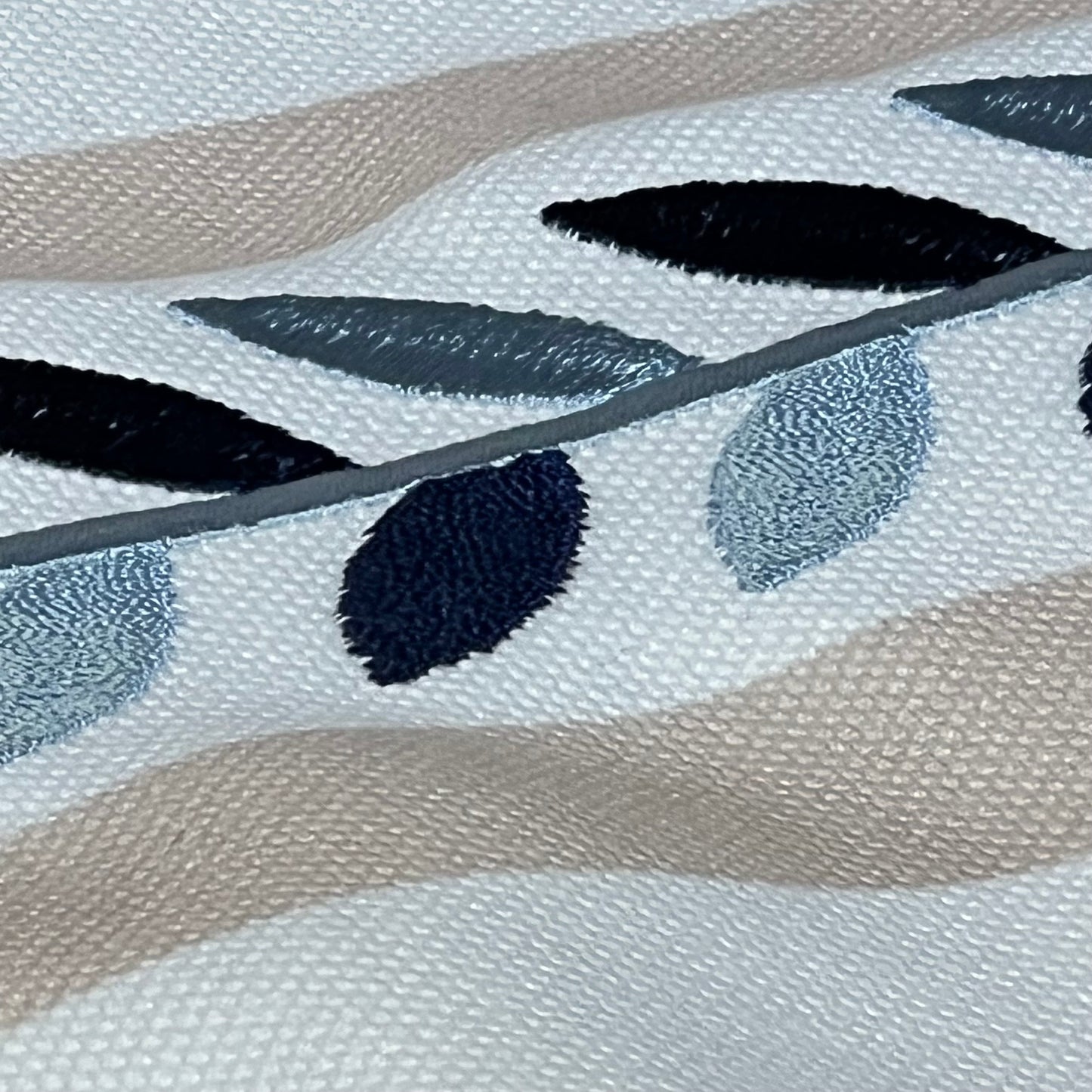 Close-up of Hofdeco lumbar pillow cover showing neutral tan embroidered leaf design with detailed piping.