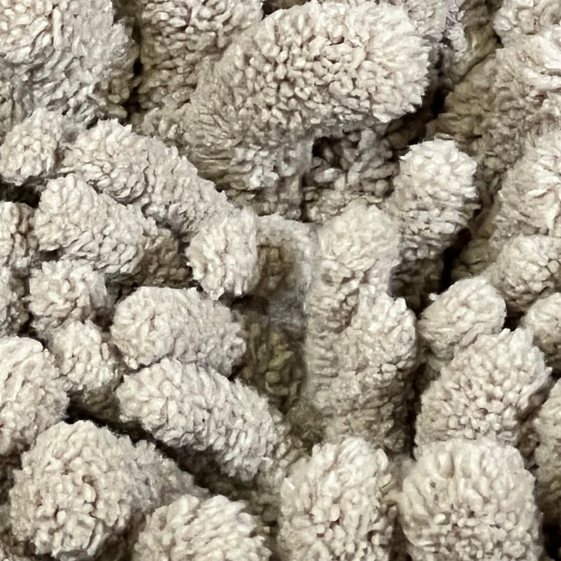 Close-up of the pale khaki Yimobra bath rug's thick, soft microfiber chenille texture, highlighting its plushness.