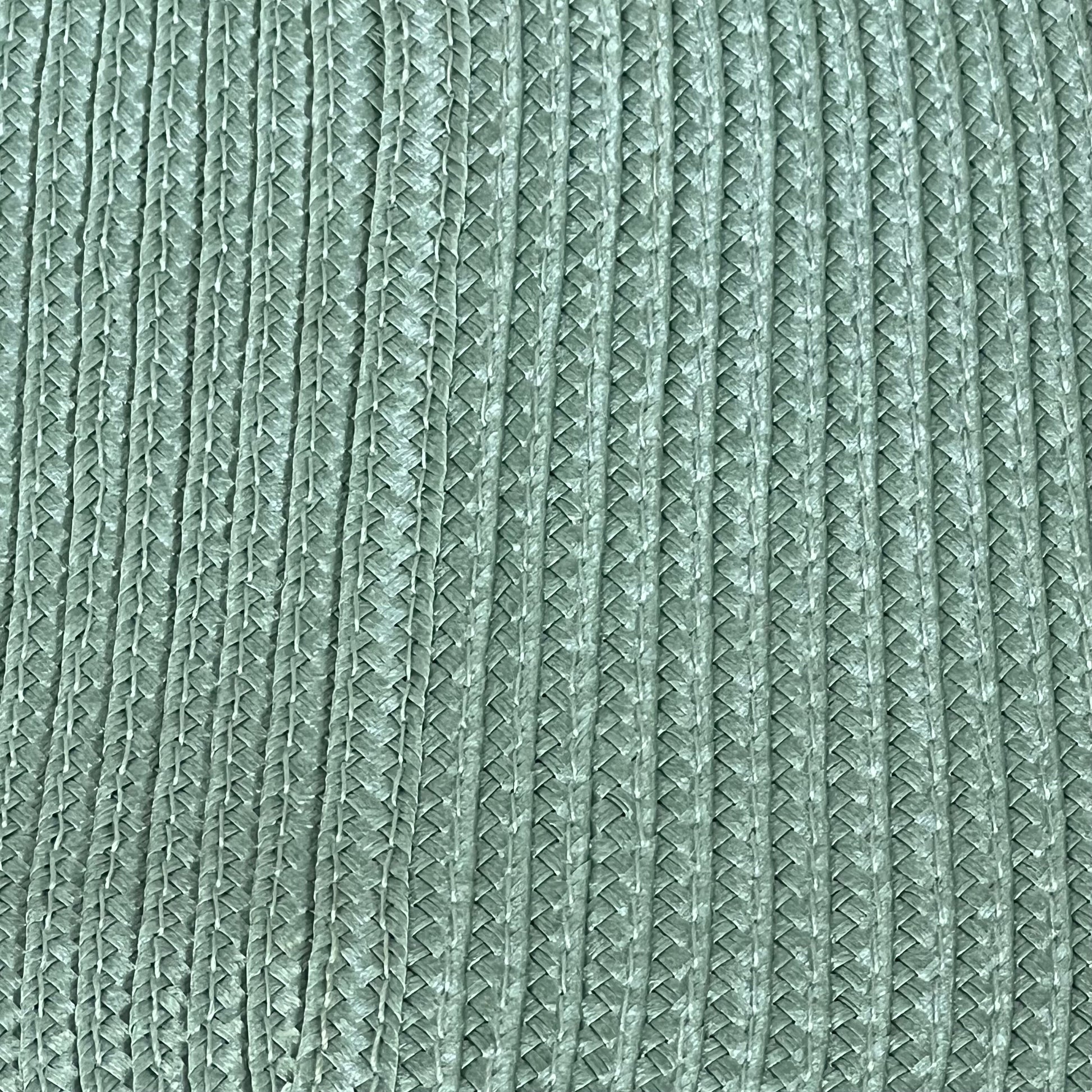 Sage green woven vinyl placemat with textured design, non-slip and heat-resistant for dining table, easy to clean.