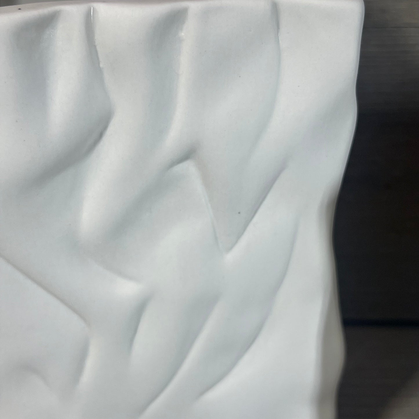 Textured surface of the Crinkle Paper Bag Ceramic Vase in Crème/Coconut Café finish with soft folds and curves.