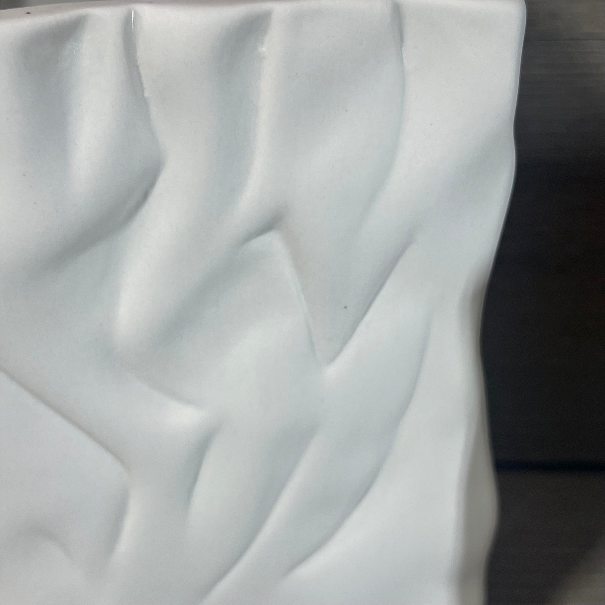 Textured surface of the Crinkle Paper Bag Ceramic Vase in Crème/Coconut Café finish with soft folds and curves.