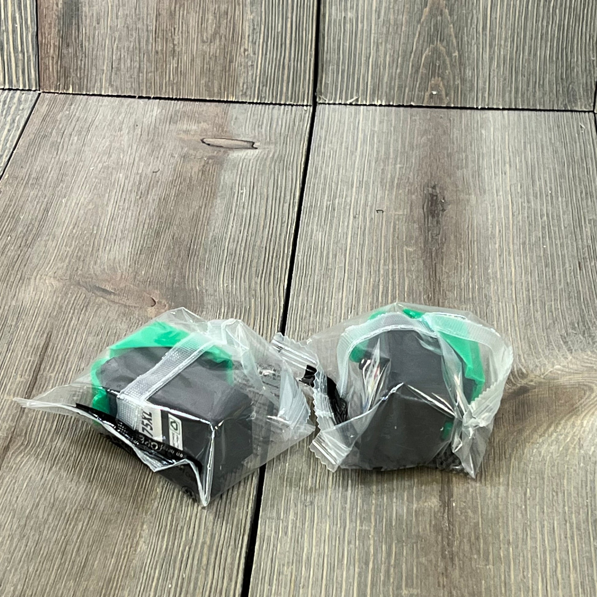 Two sealed replacement Canon ink cartridges for PIXMA printers, compatible with PG-275 XL/CL-276 XL, on a wooden surface.