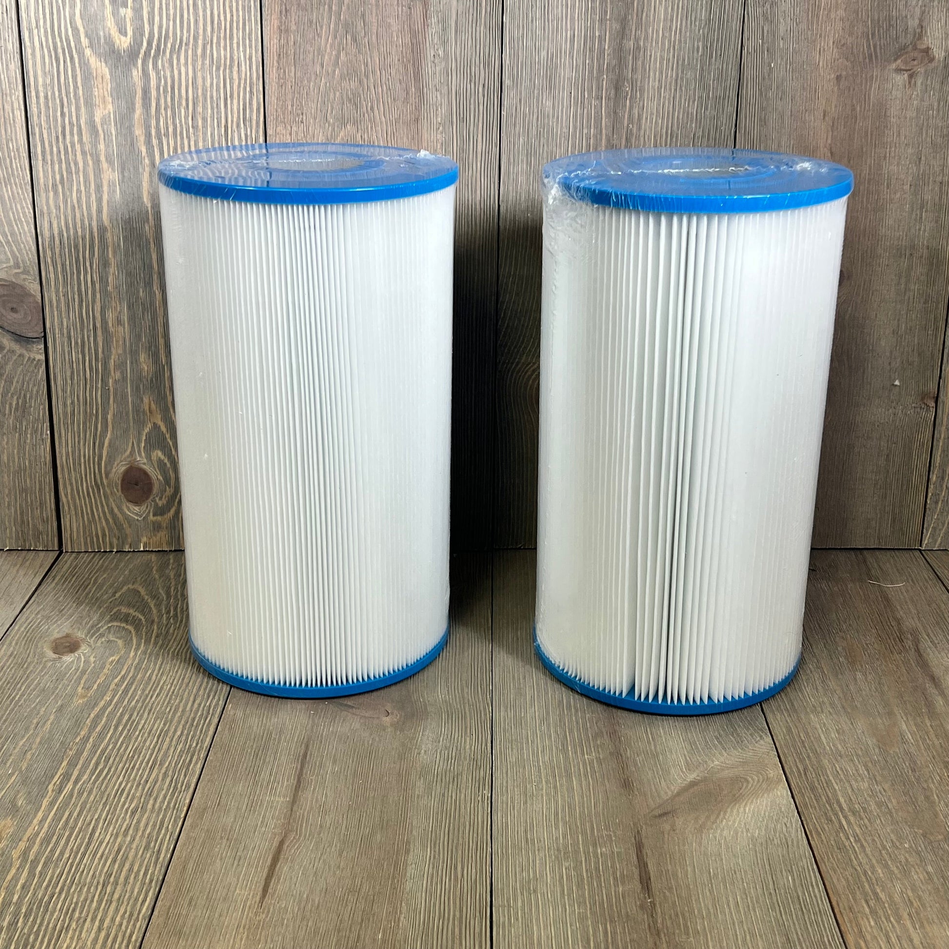 Dual Yoozell PWK30-EC spa filter cartridges with blue caps on wooden surface, perfect for hot tubs, 30 sq.ft each.