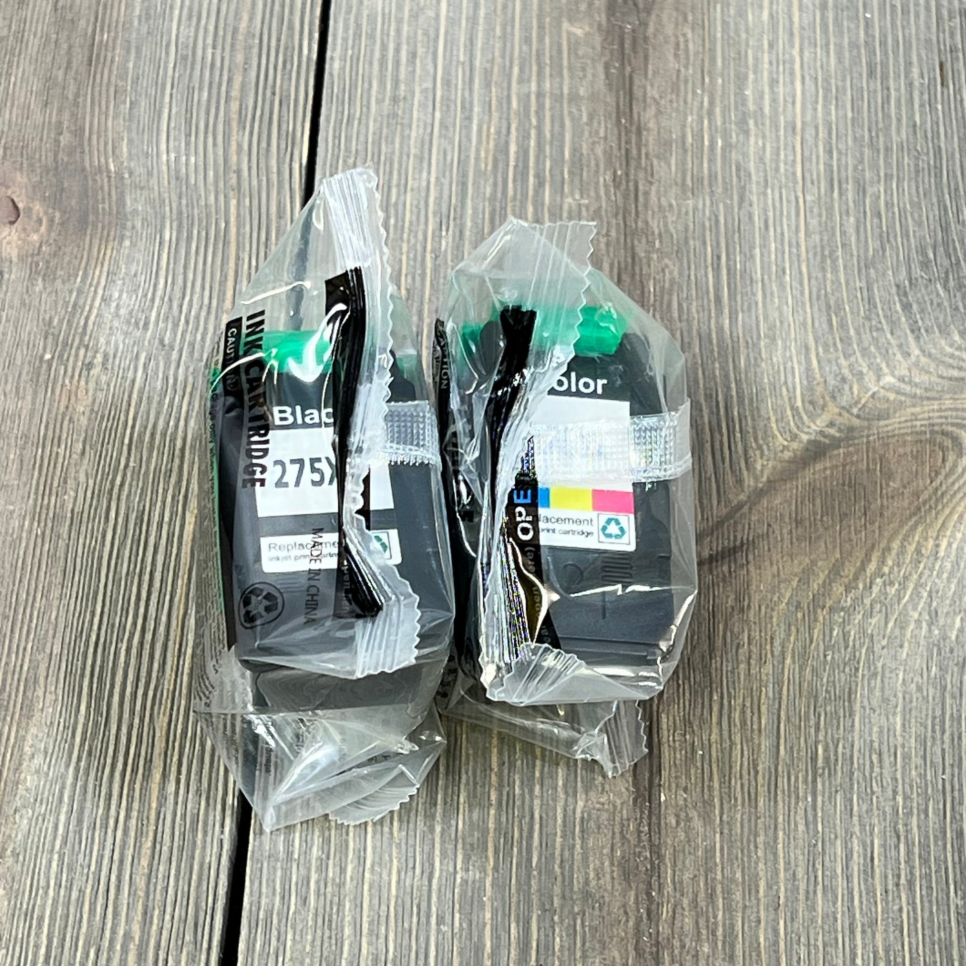 Canon 275XL and 276XL ink cartridges in packaging, compatible with PIXMA TS and TR series printers, on wooden surface.