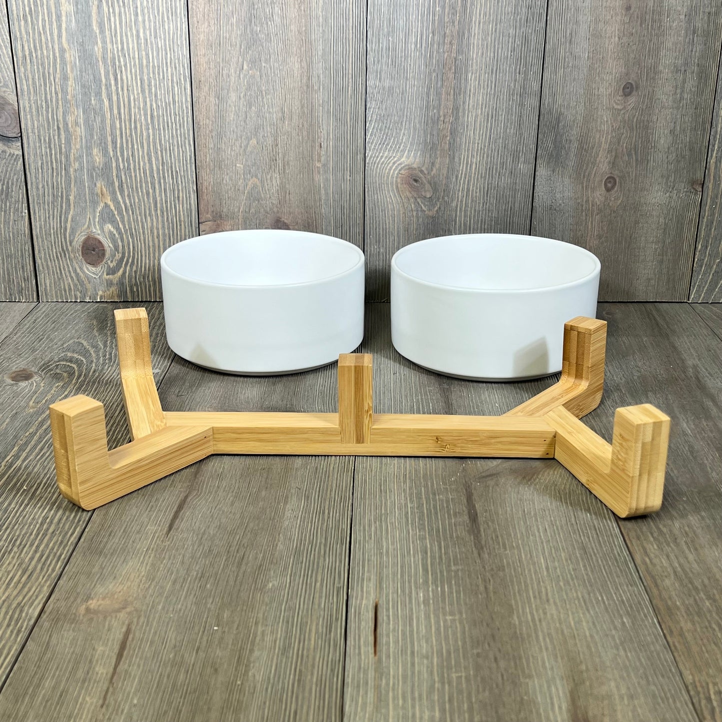 Ceramic dog and cat bowls with a sleek wood stand, perfect for medium pets. Non-slip design with a matte glaze finish.