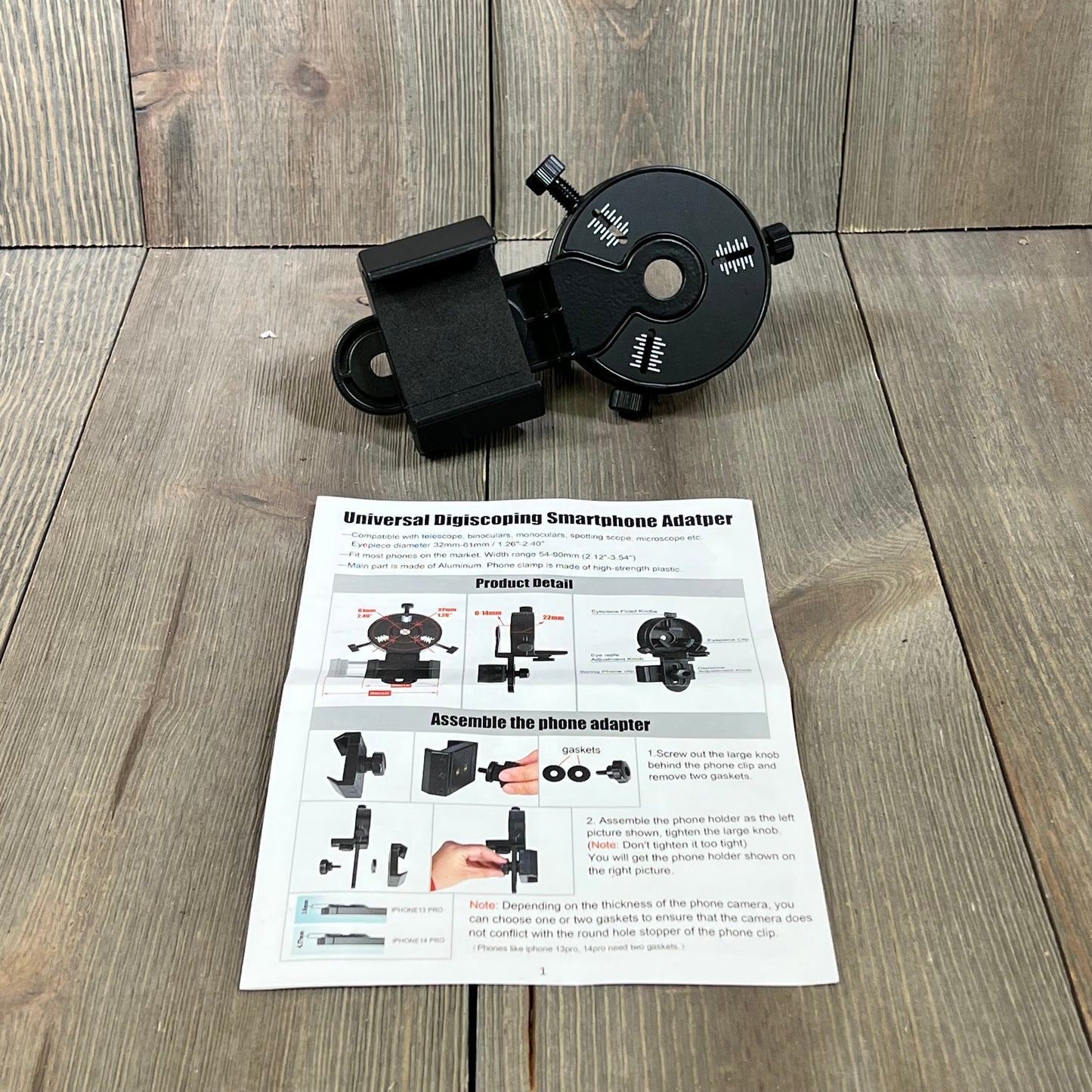 Smartphone scope adapter displayed on wooden surface with assembly instructions, ideal for spotting scopes and telescopes.
