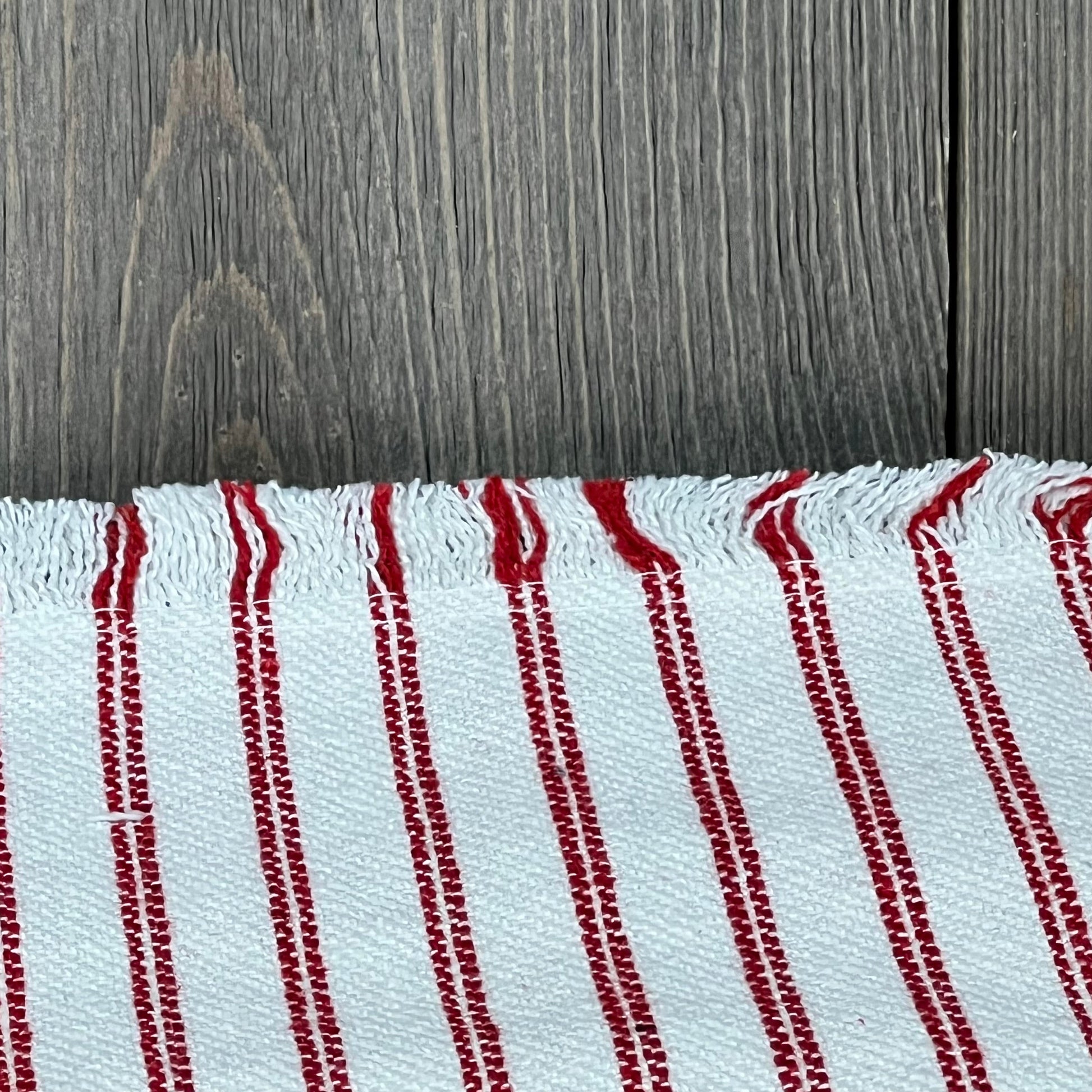 Red and white striped farmhouse throw pillow cover with fringe tassels, adding boho chic to a modern neutral decor.