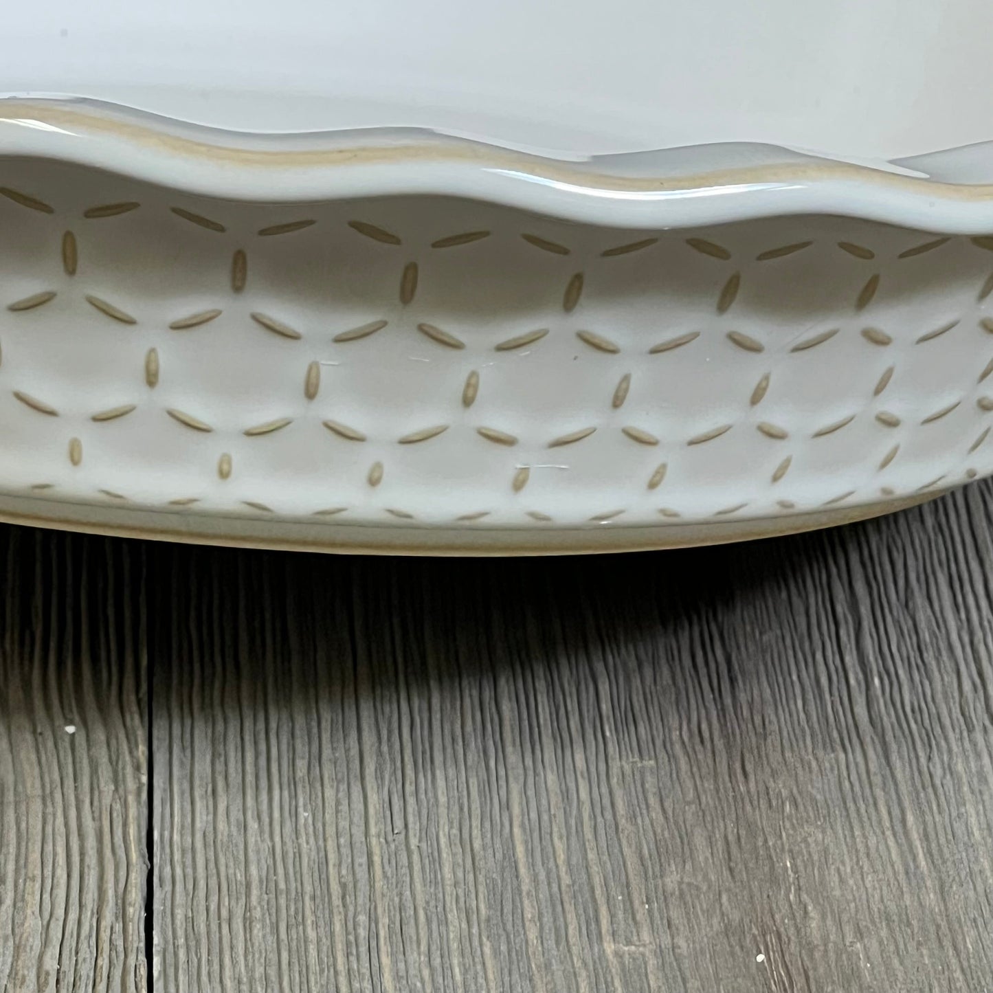 Stoneware pie dish with embossed pattern, showcasing fluted edge design, ideal for baking pies, quiches, and tarts.