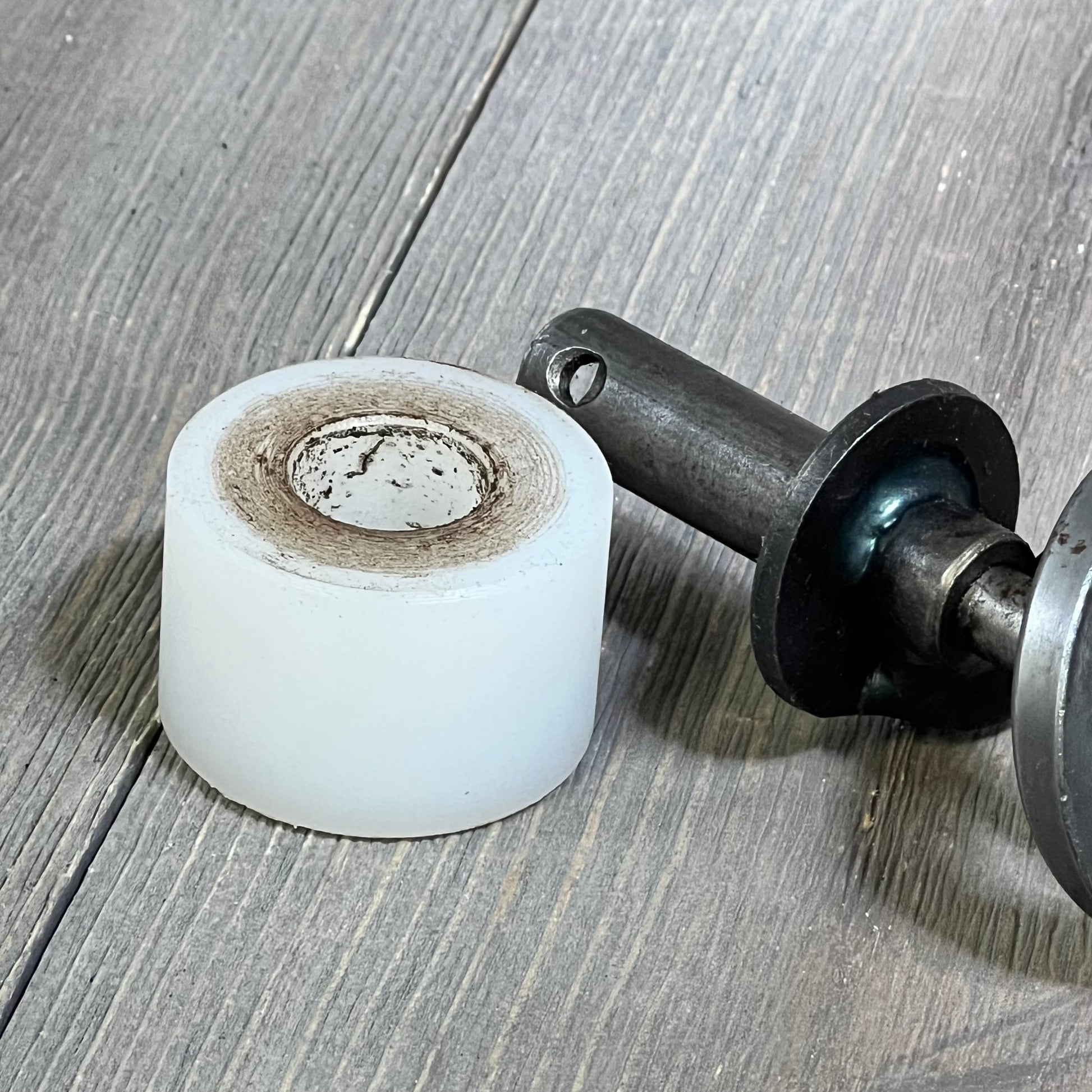 17-inch auger shaft and motor bushing kit on wood surface, compatible with Traeger pellet grills for efficient fuel feeding.