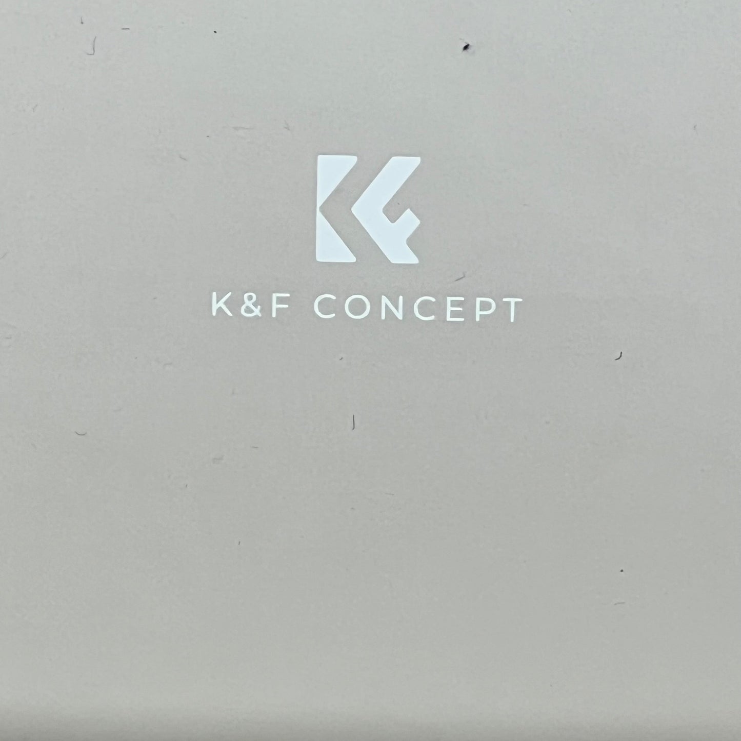 Beige K&F Concept camera case logo, showcasing brand identity on smooth surface, ideal for compact, stylish protection.