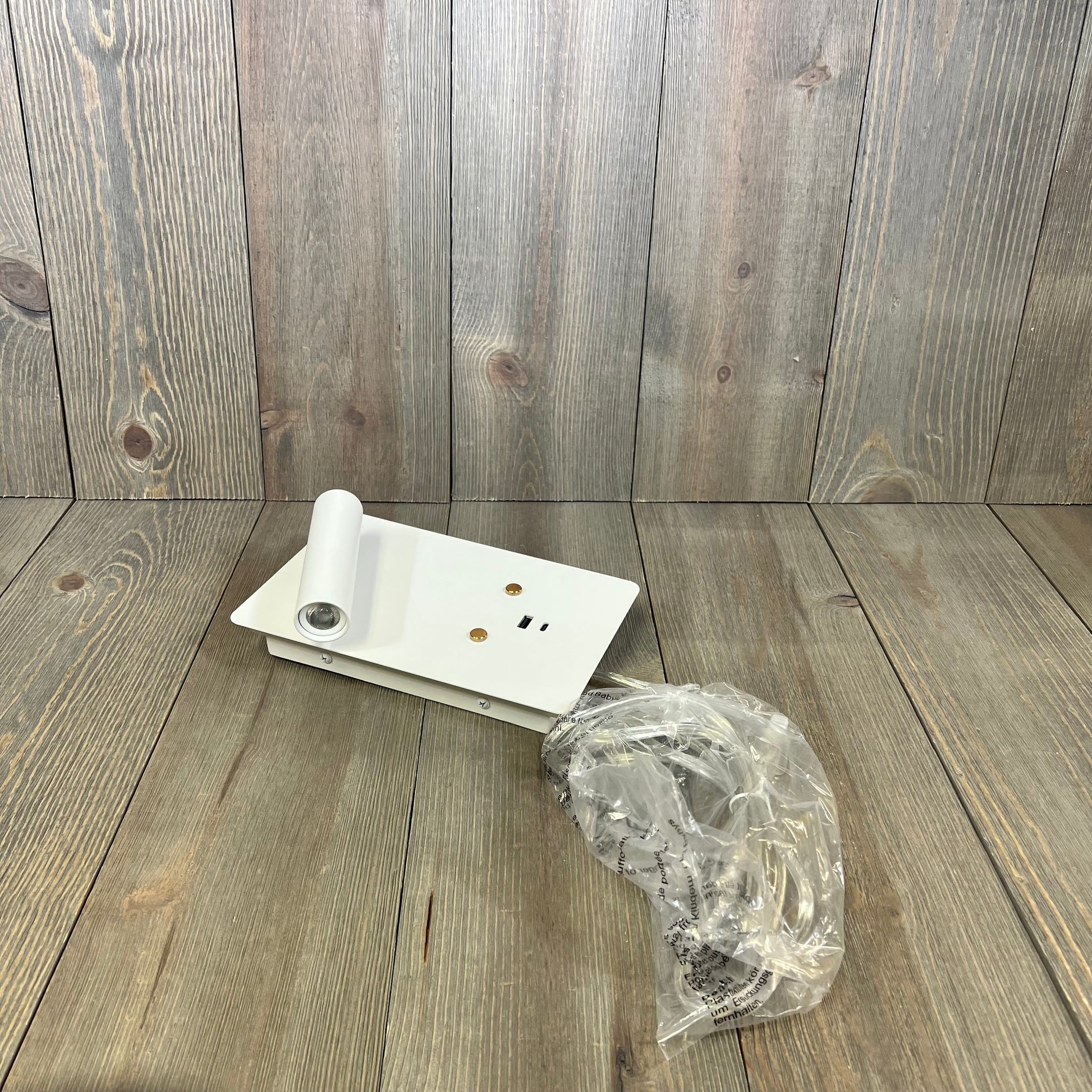 White wall-mounted reading light with dimmable LED, USB A+C ports, and touch control, ideal for bedroom use.