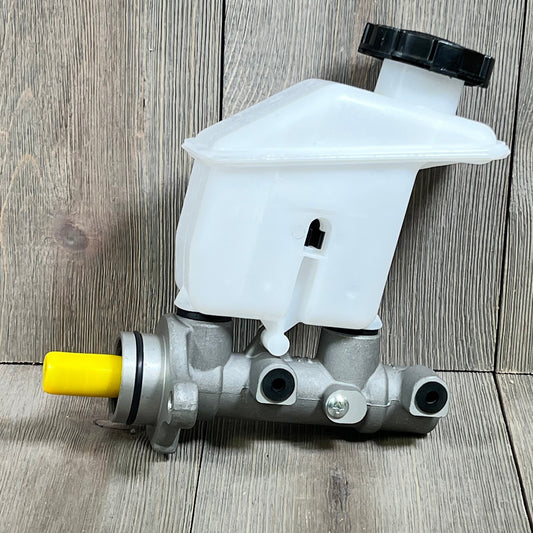 Silver and white brake master cylinder with reservoir for Kia Rio 2006-2011, durable hydraulic component with yellow cap.