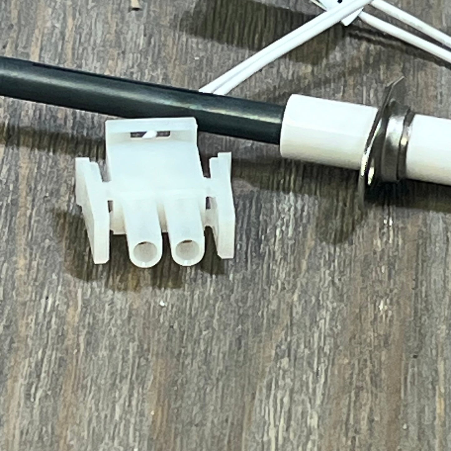 Silicon Nitride Ignitor Kit for Hayward H-Series Heaters, featuring cylindrical igniter head and connector on wood surface.