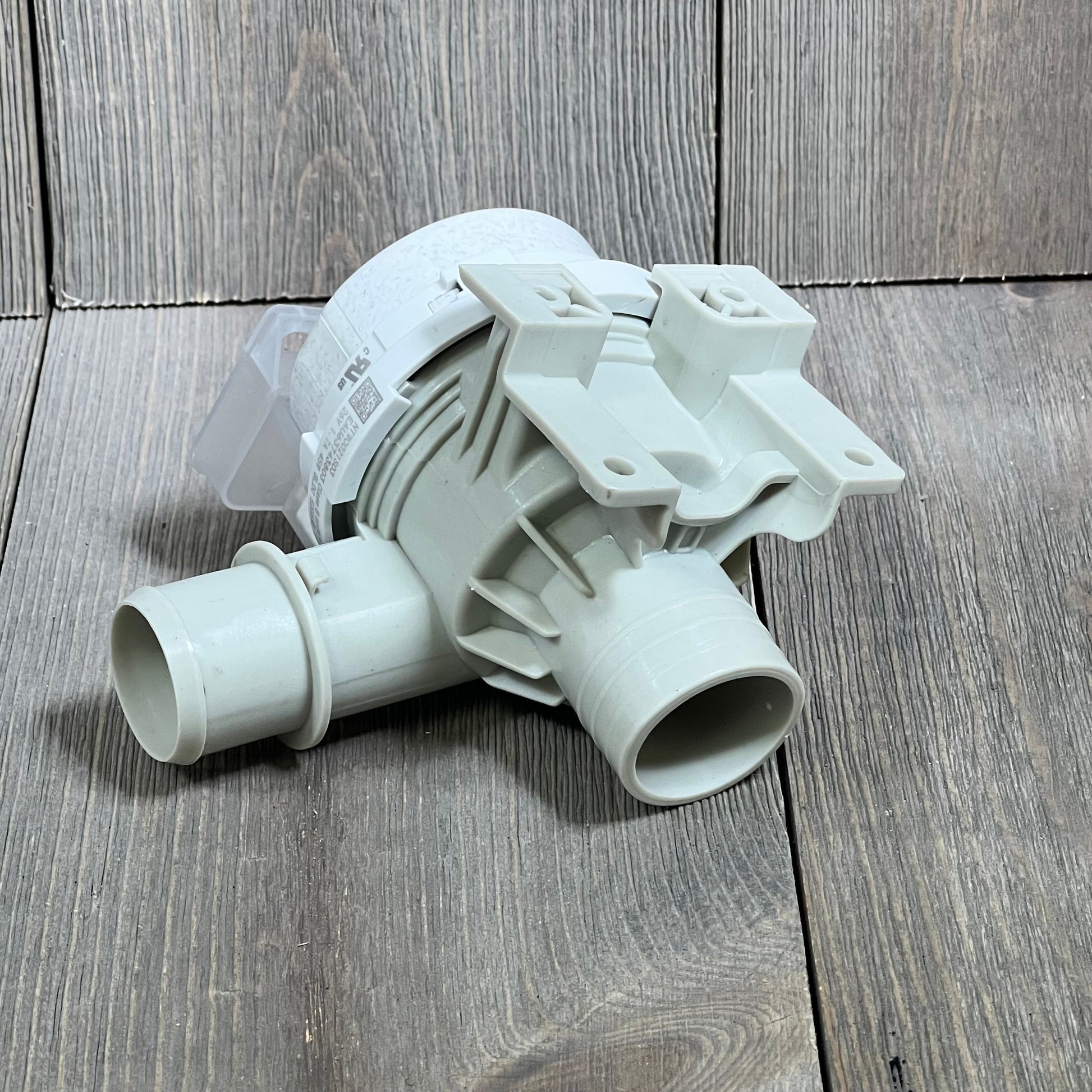 Upgraded LG washer drain pump assembly, model AHA75673404, displayed on a wooden surface, compatible with multiple models.